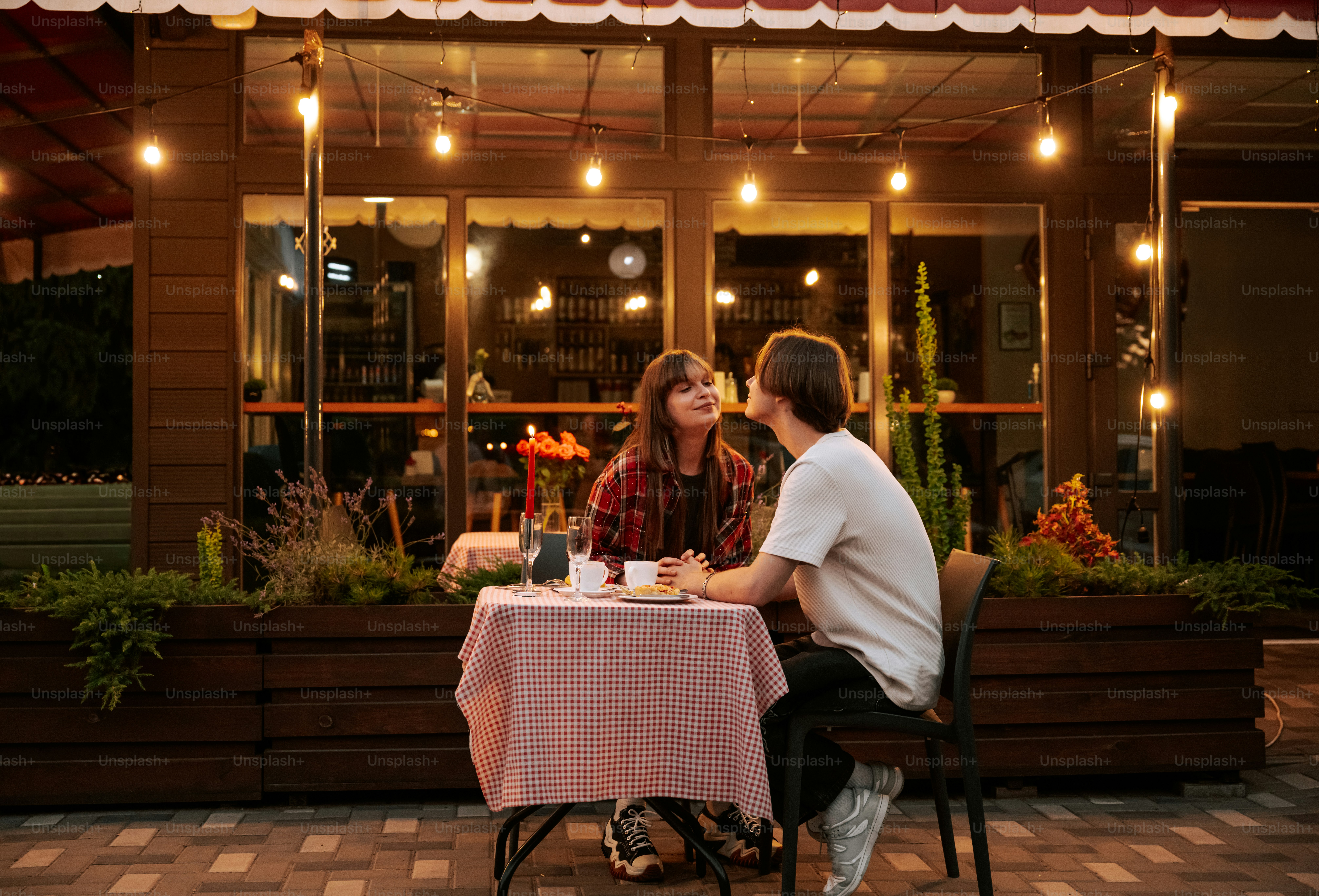 Couple on outdoor restaurant date under string lights