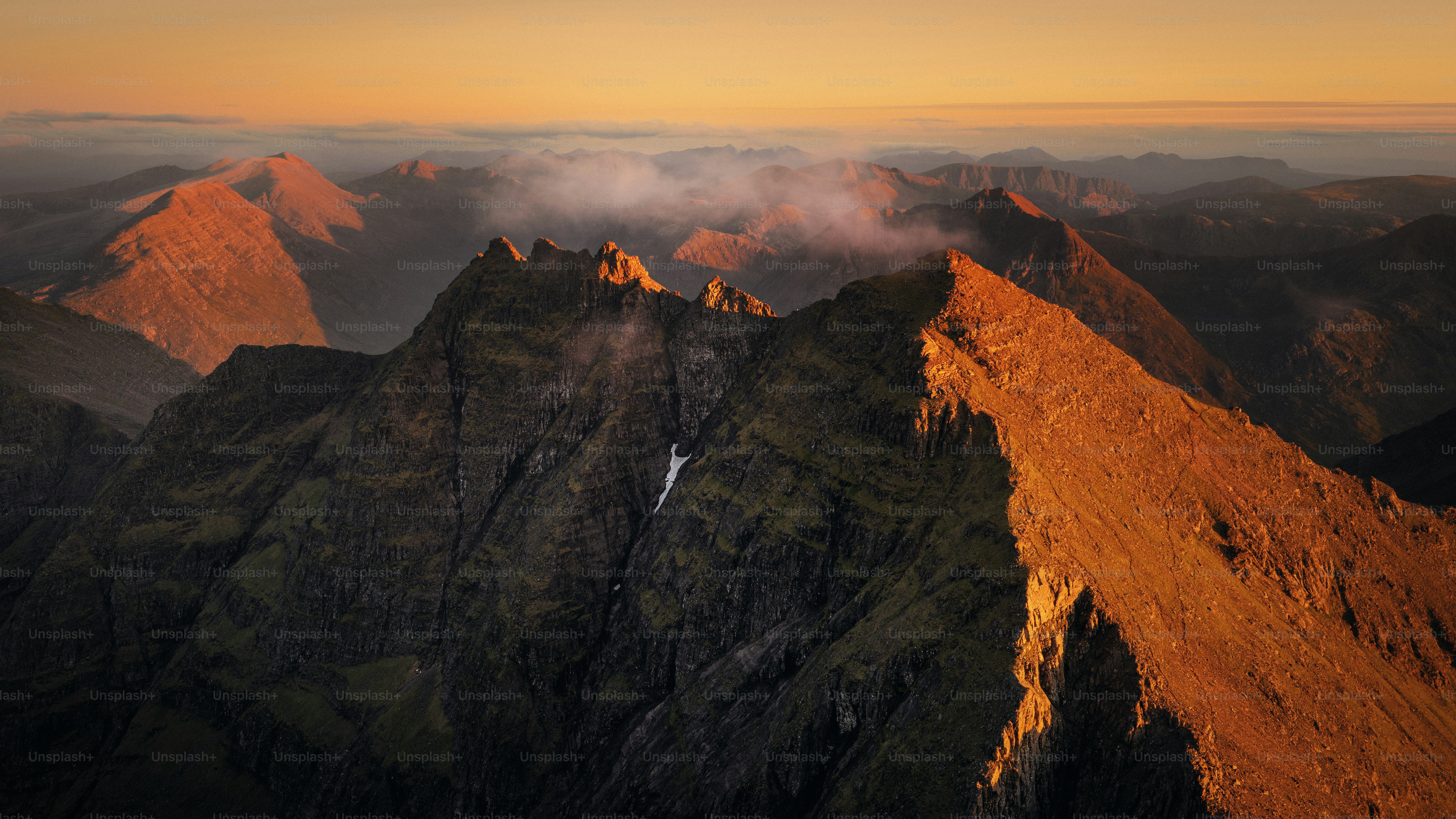 Dramatic mountain ridge bathed in golden sunrise light