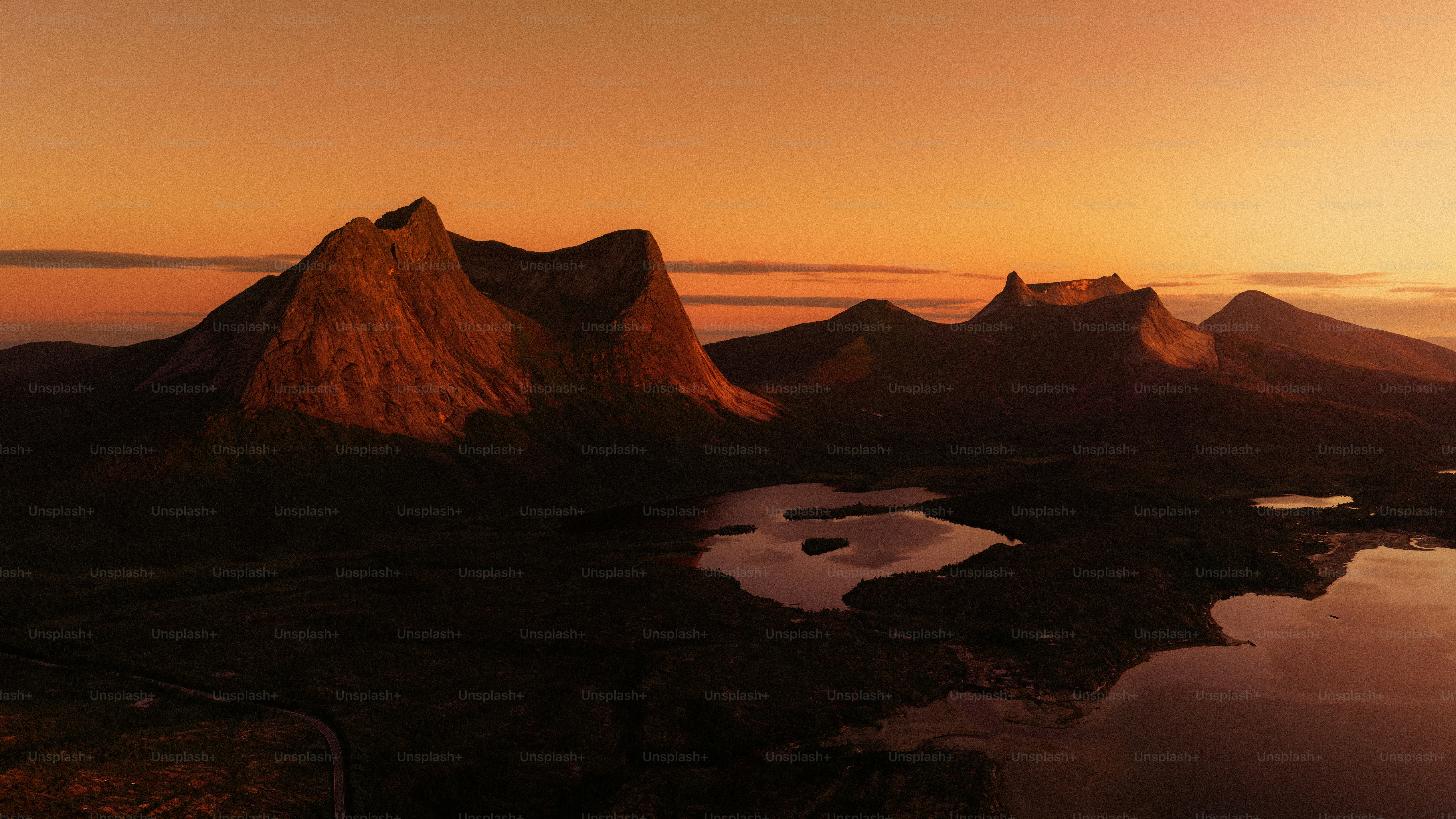Golden sunset over mountains and calm water