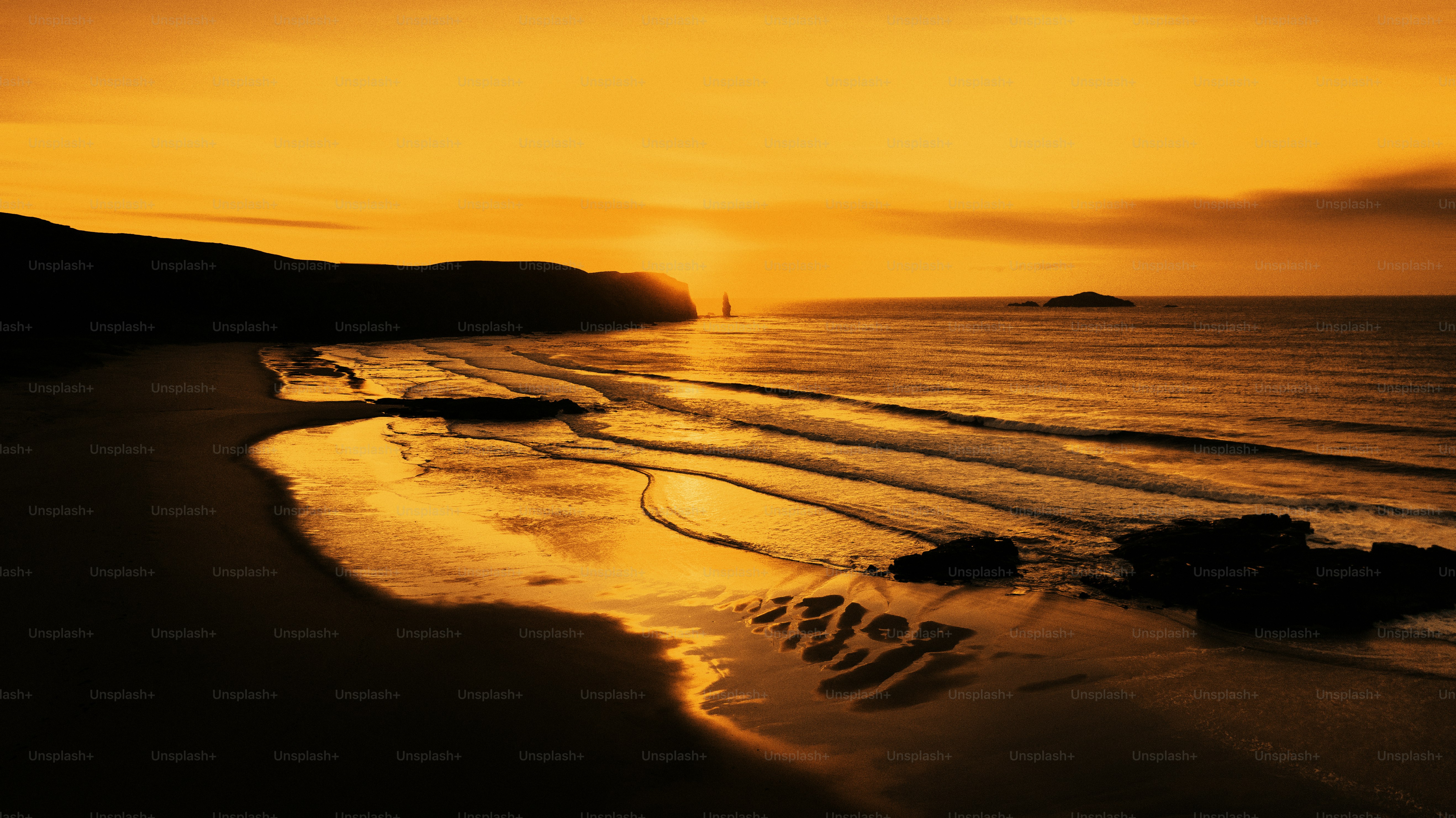 Golden sunset reflects on beach and ocean