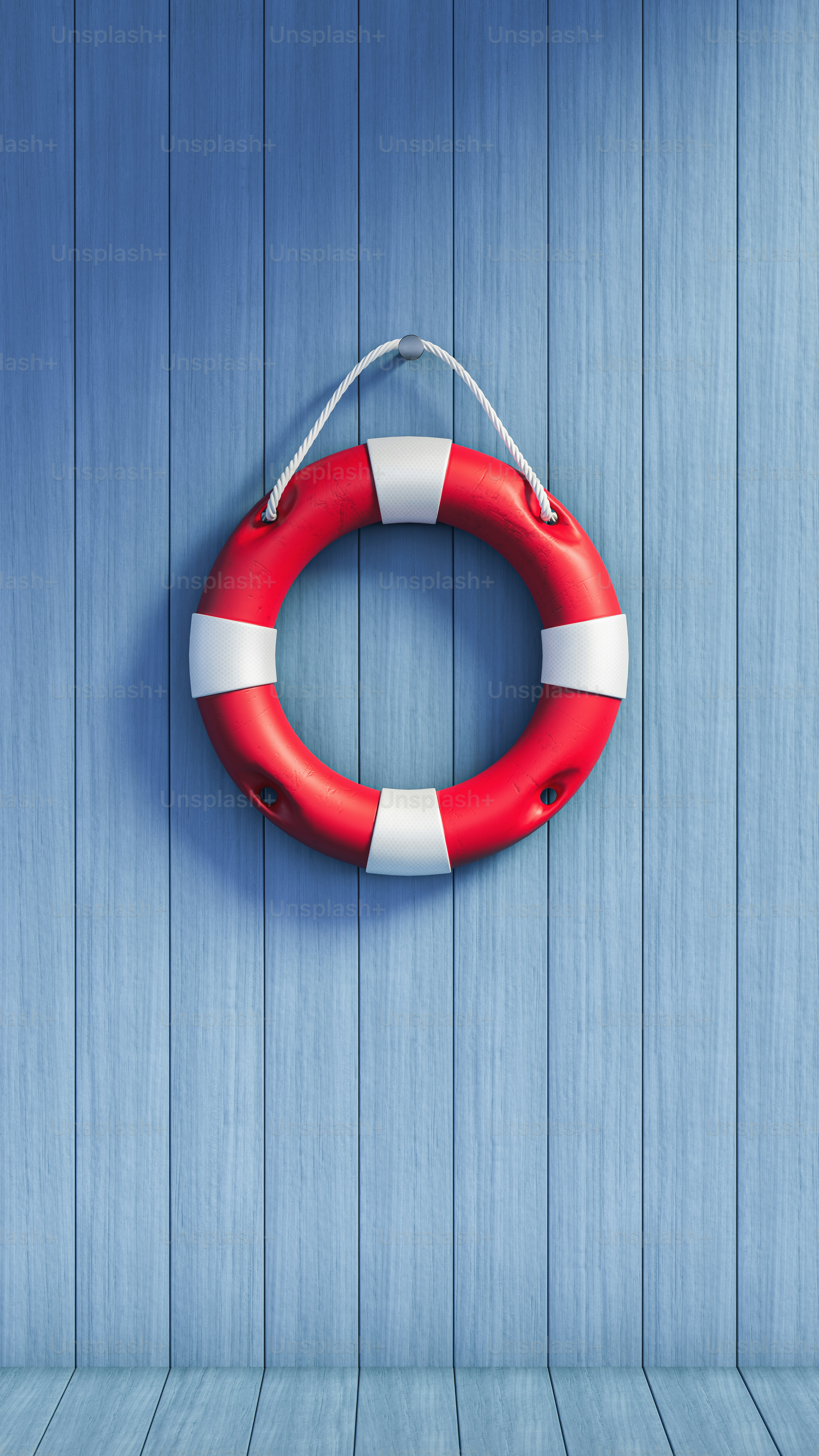 Red and white lifebuoy hanging on blue wooden wall