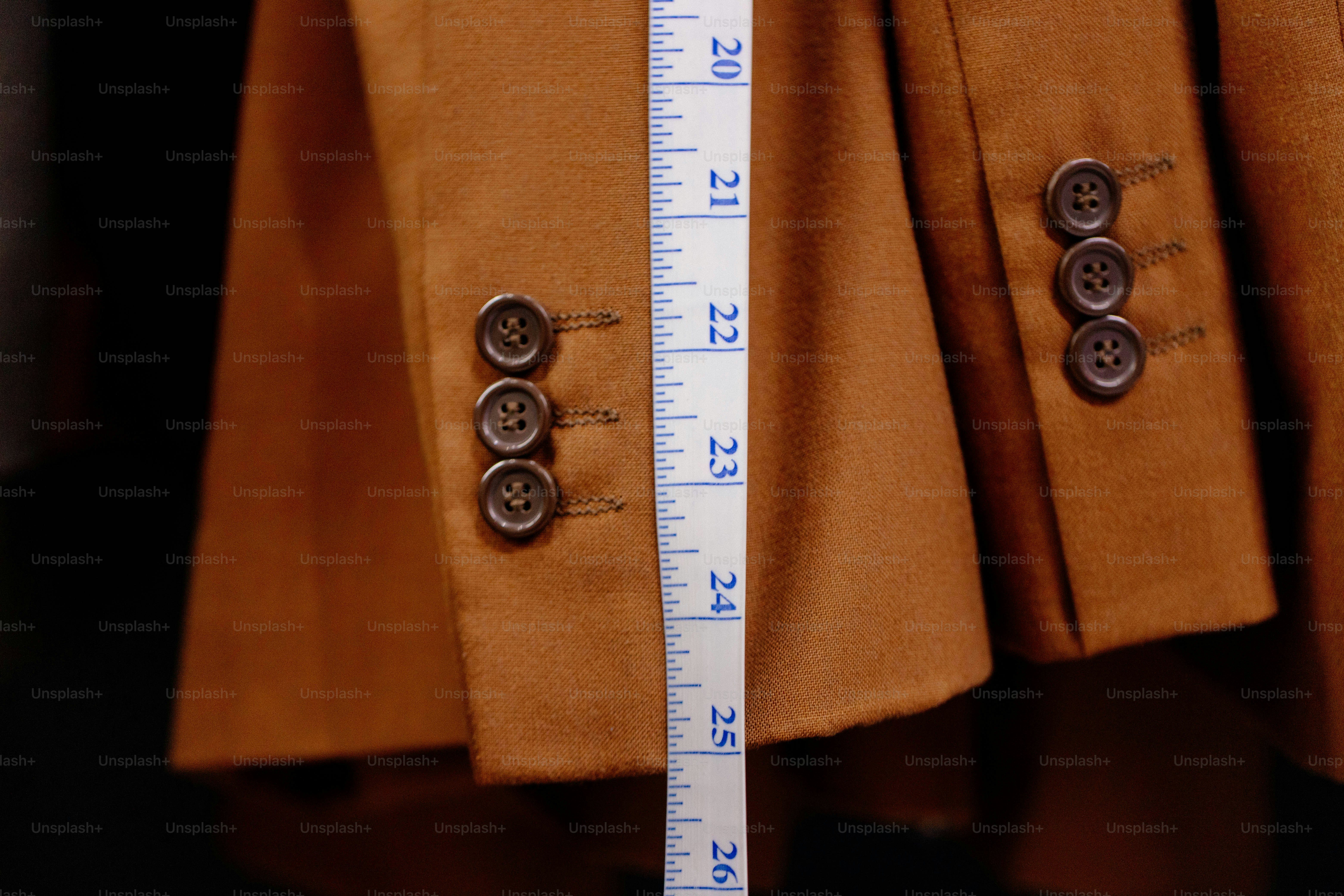 Measuring brown jacket sleeve with tape