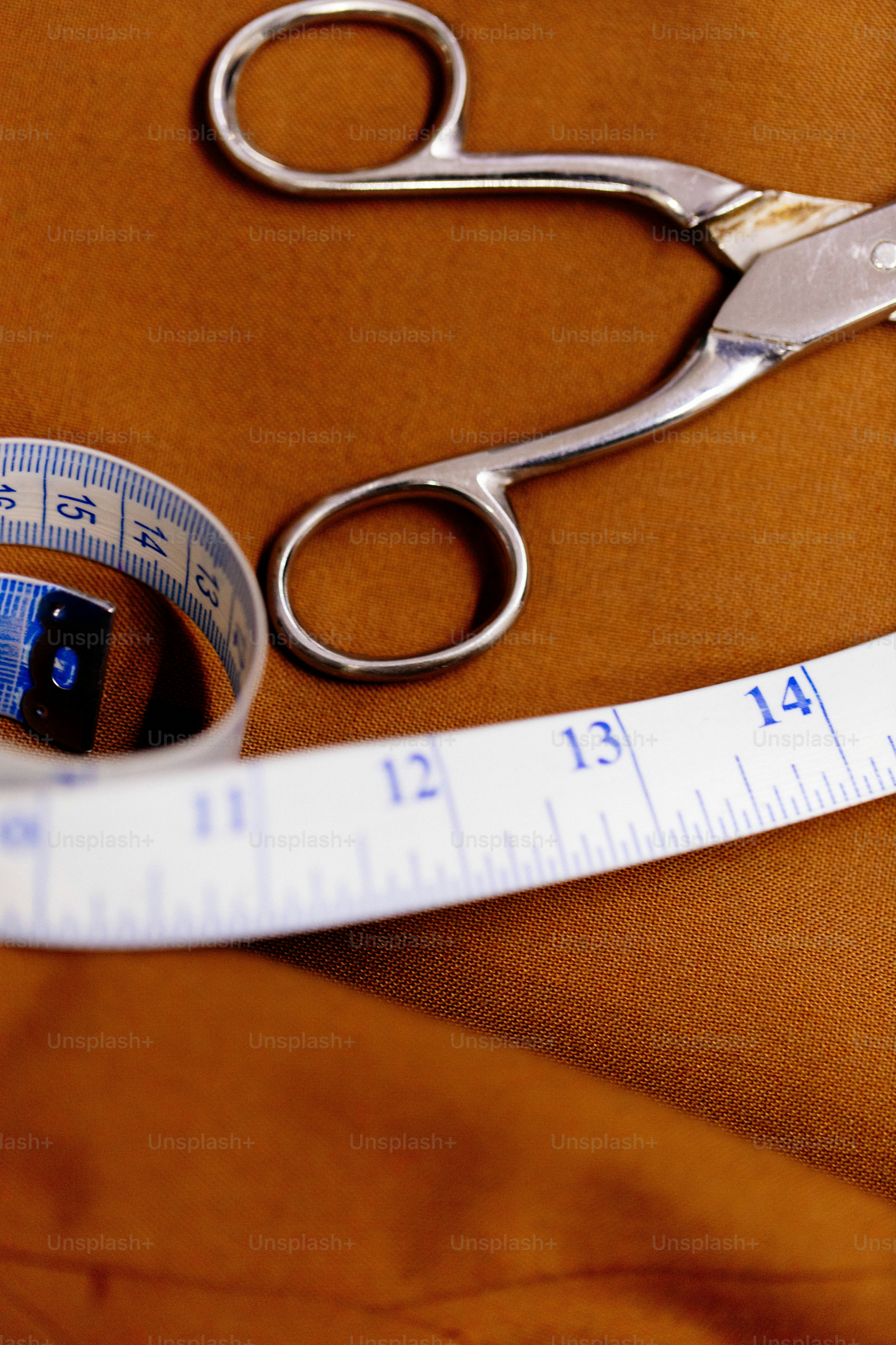 Scissors and measuring tape on brown fabric