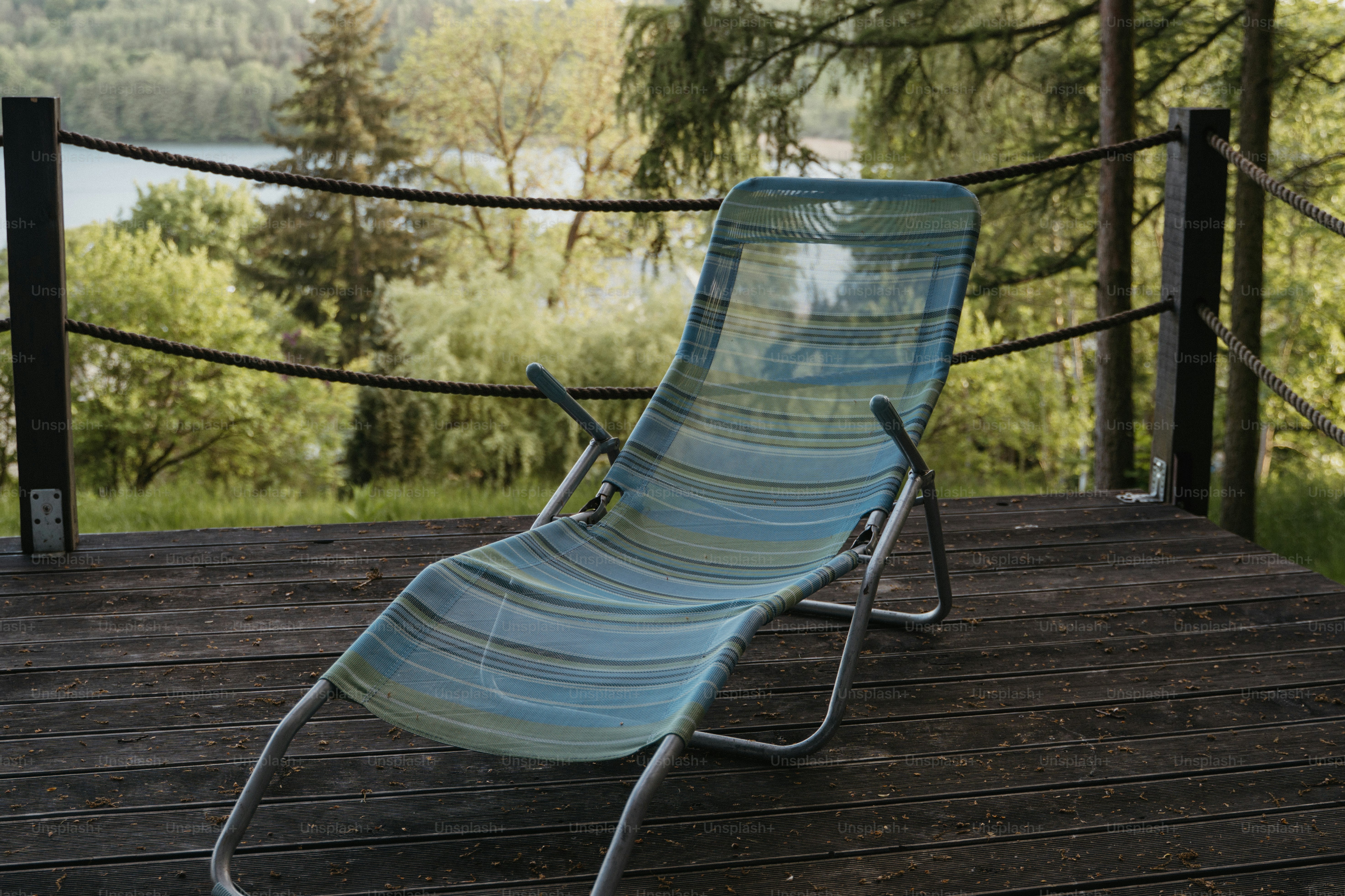 Striped lounge chair on wooden deck overlooking lake