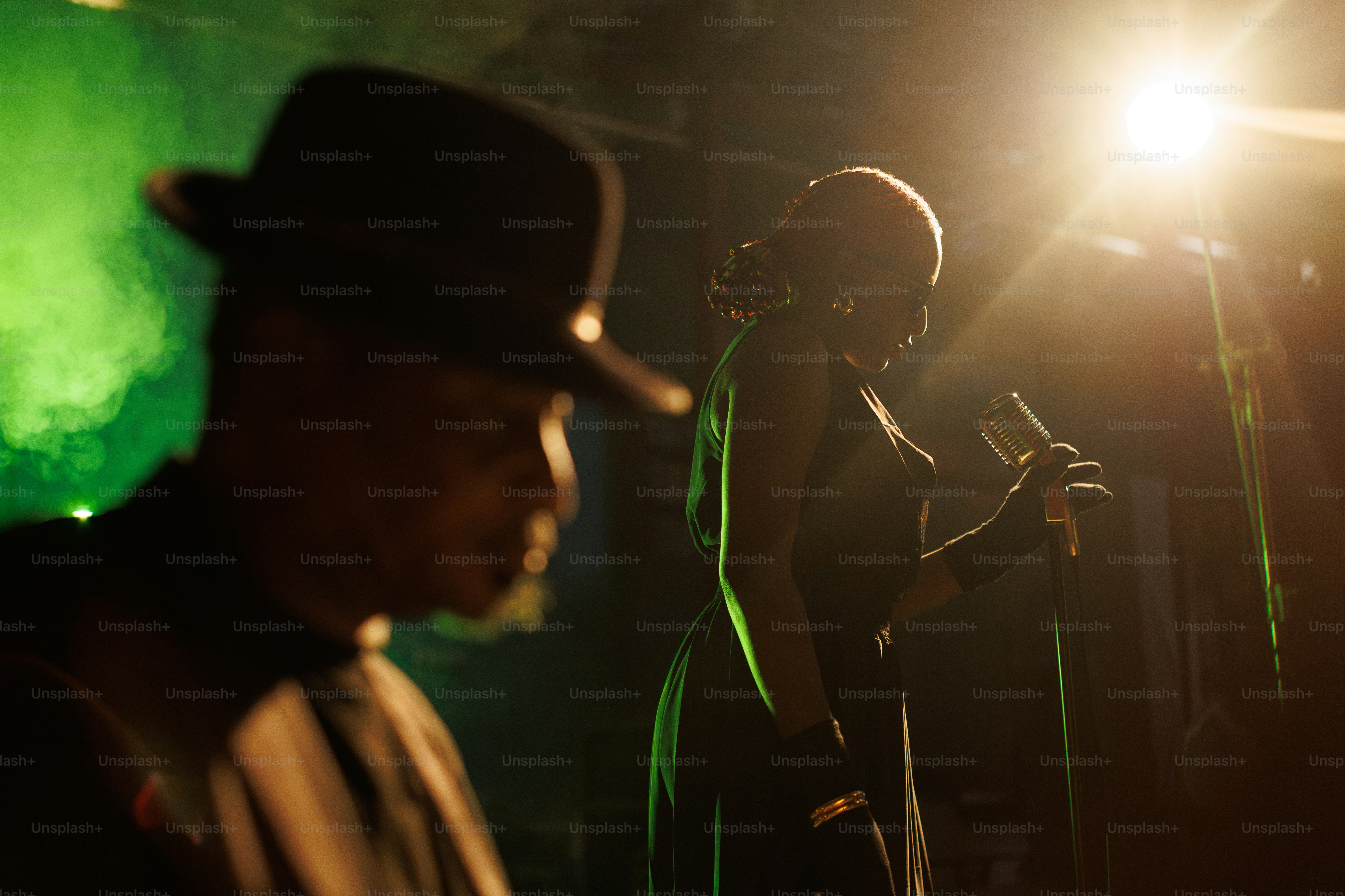 Chanteur se produisant sur scène sous projecteur vert