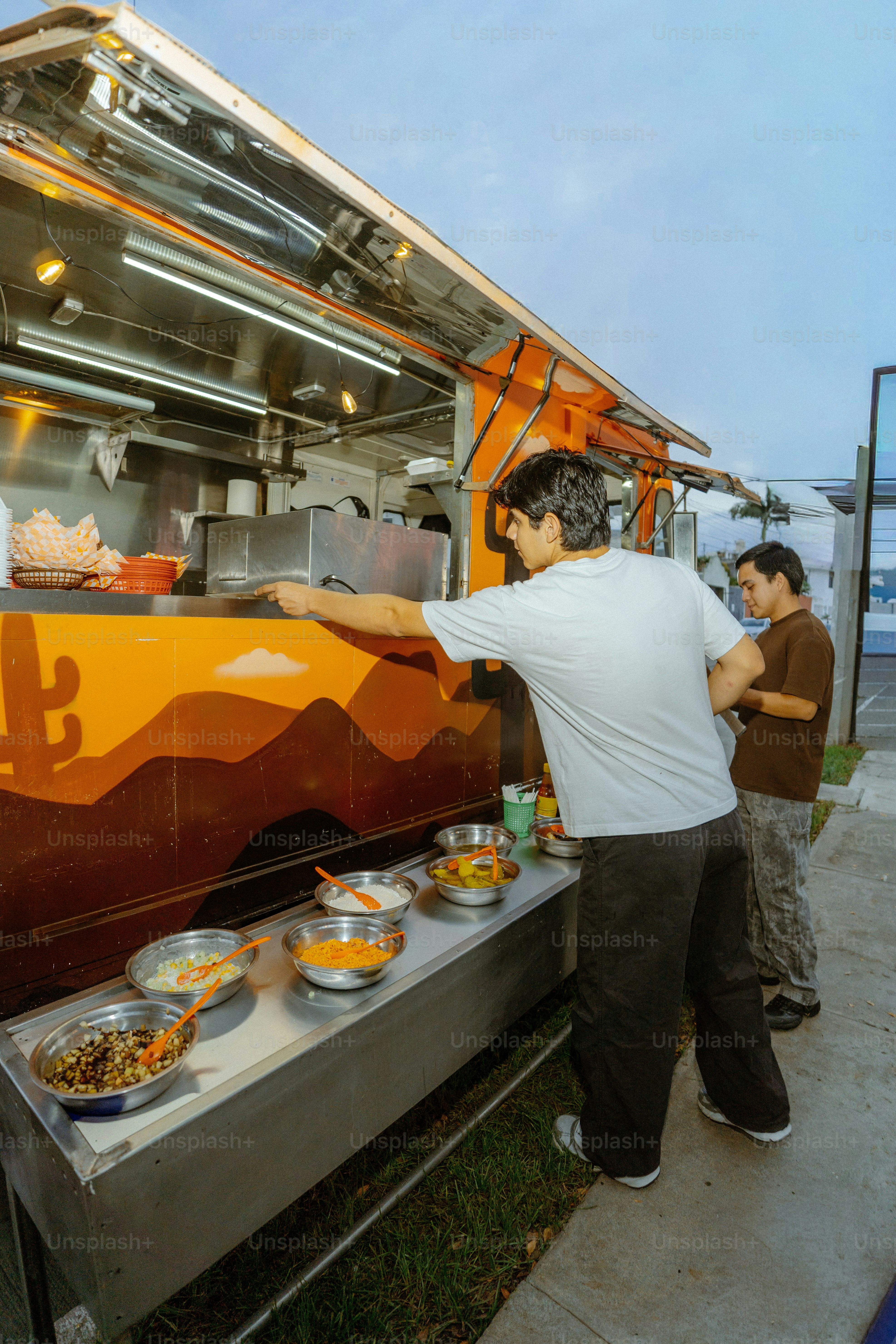 カラフルなフードトラックから料理を配る男性