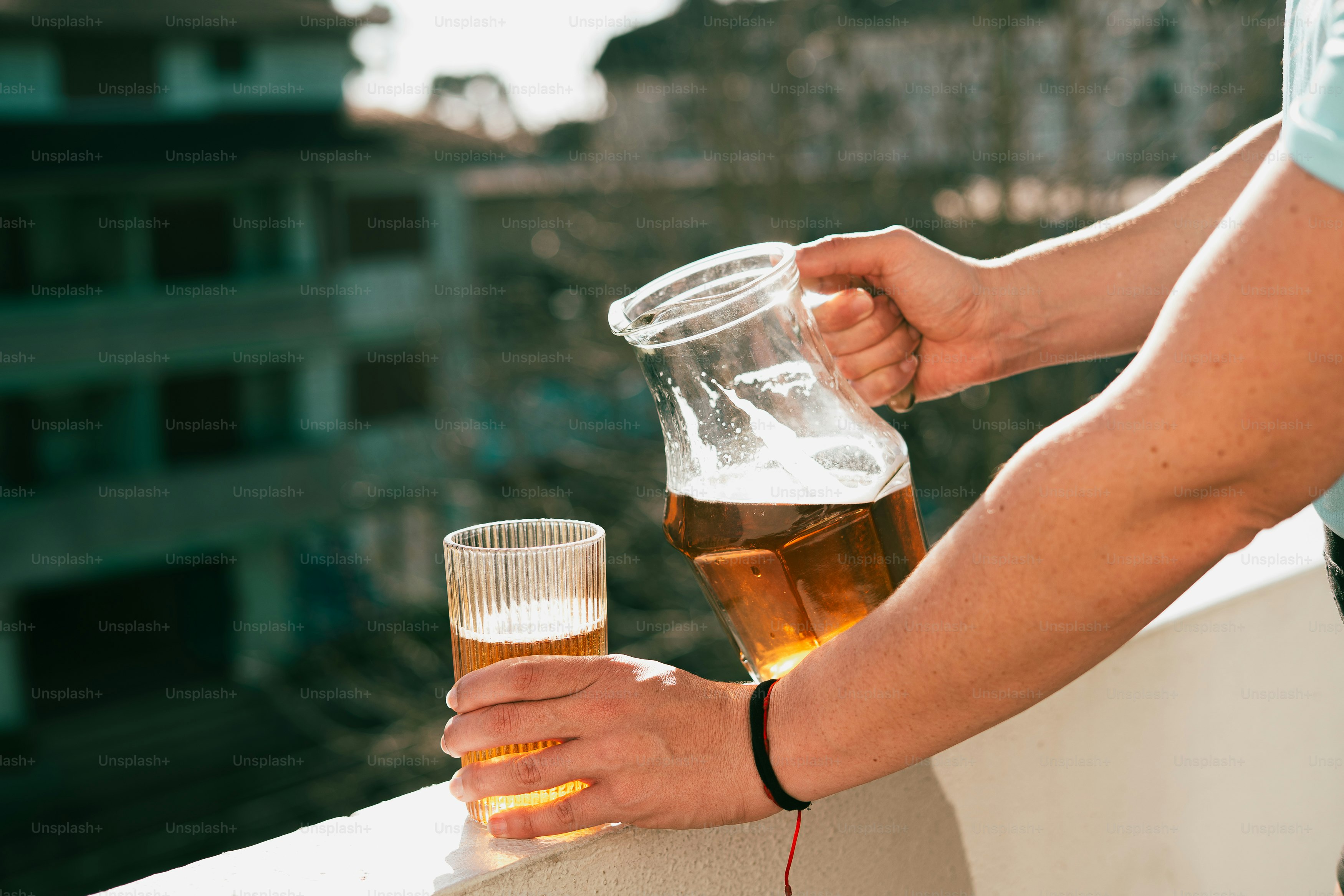 Verser de la bière de la carafe dans un verre sur le balcon