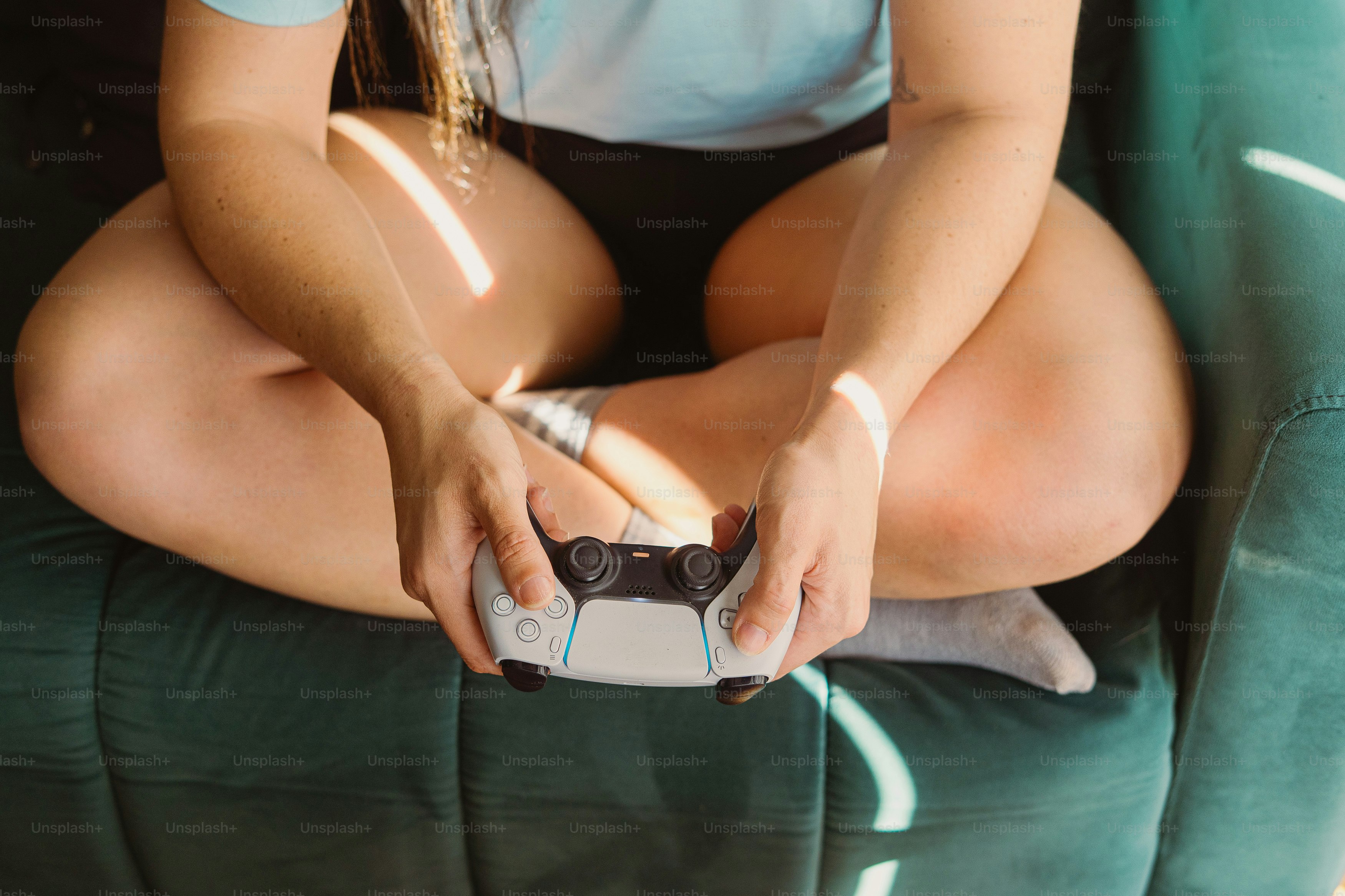 Femme sur le canapé tenant une manette de jeu vidéo blanche