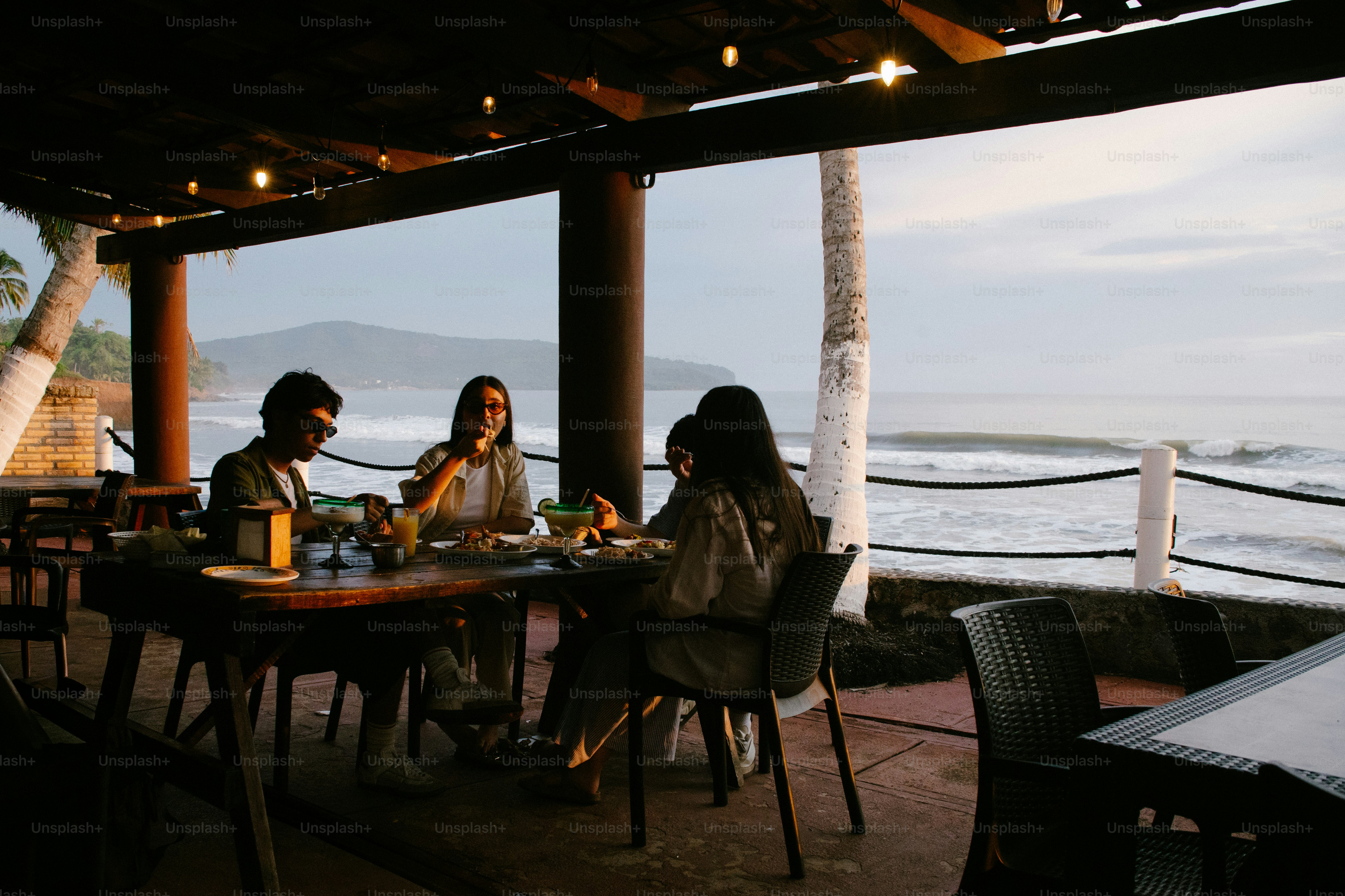 Invités dînant dans un restaurant en bord de mer pendant le crépuscule