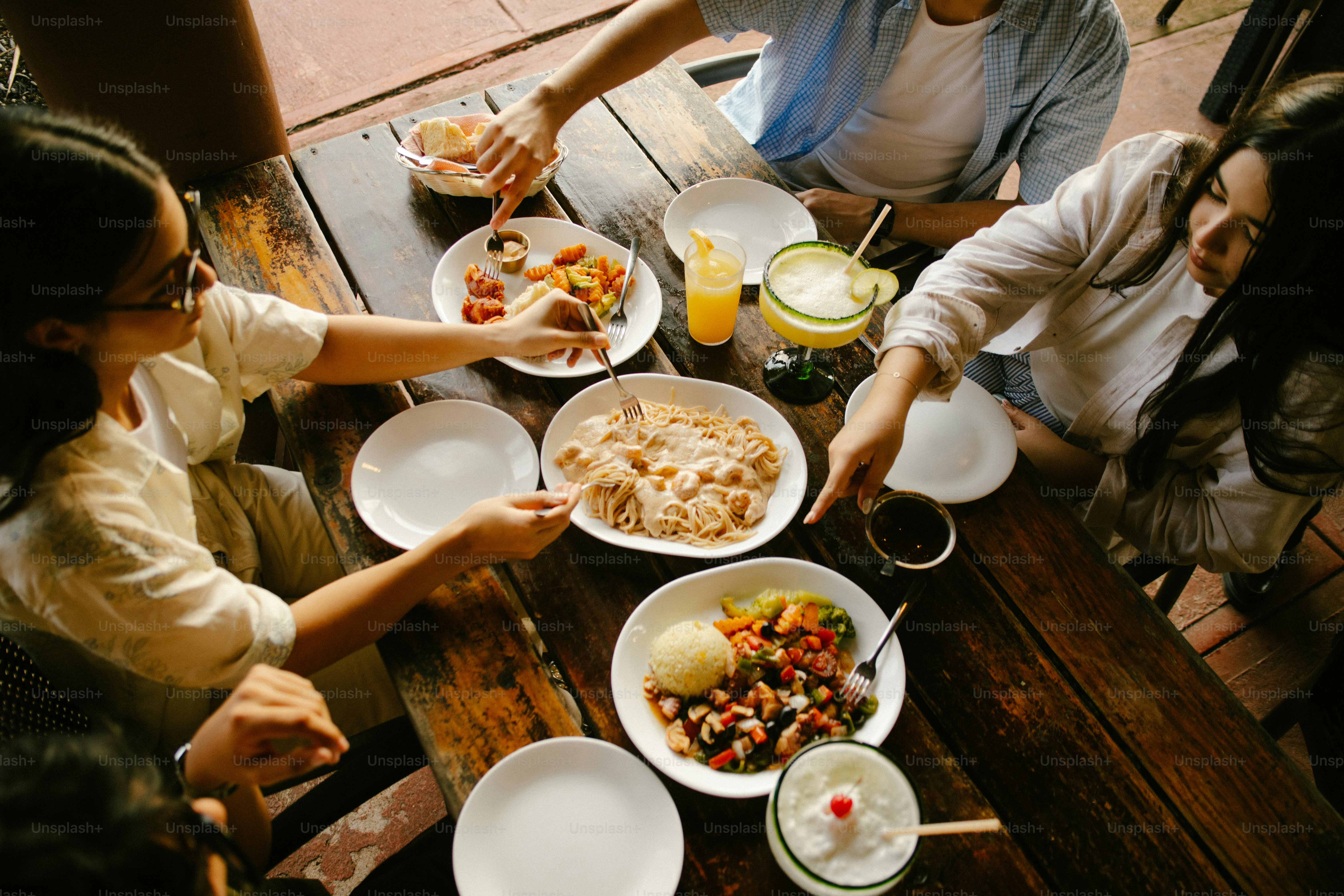 Des amis partageant un repas à une table rustique en bois