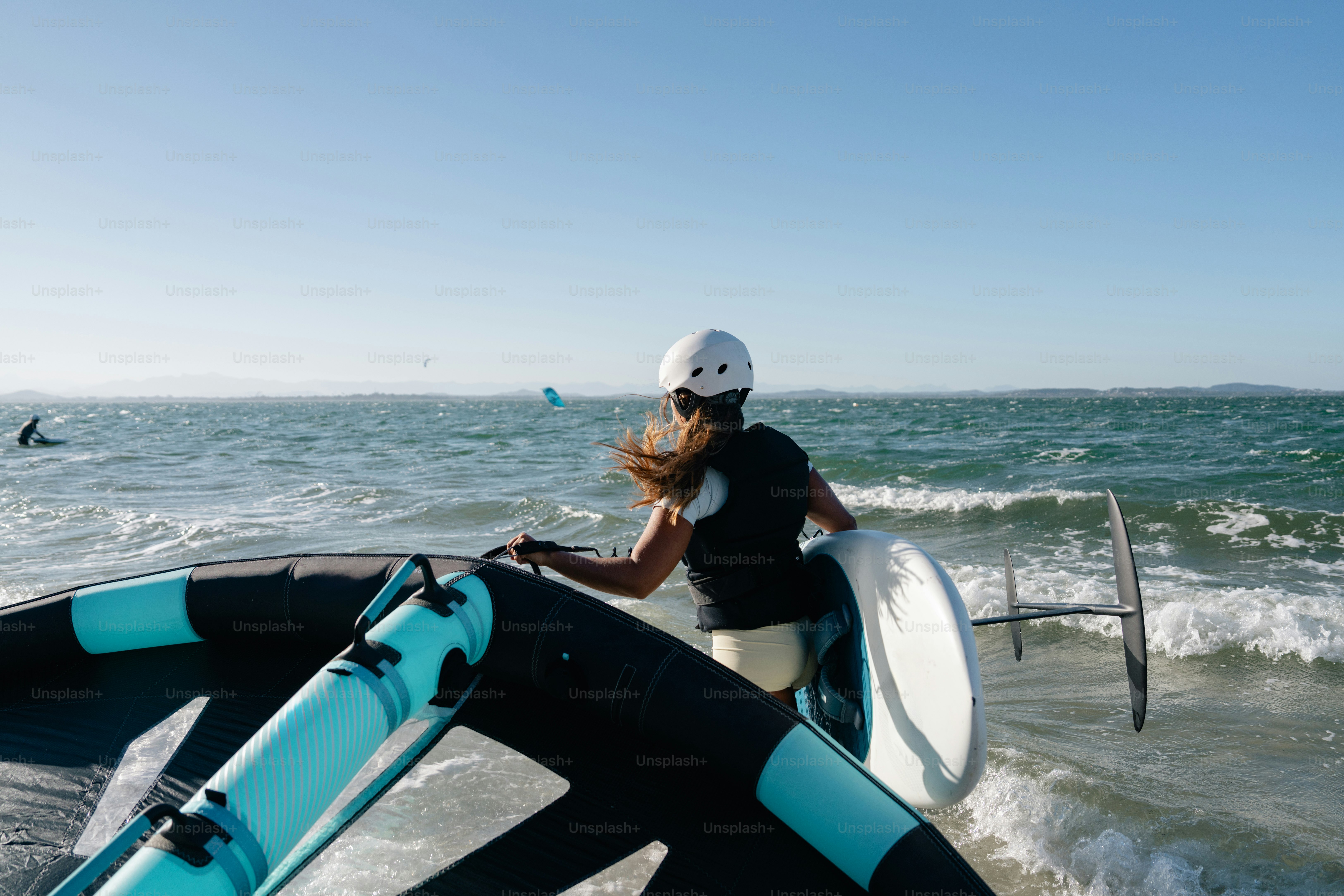 Woman wing-foiling with board in choppy ocean