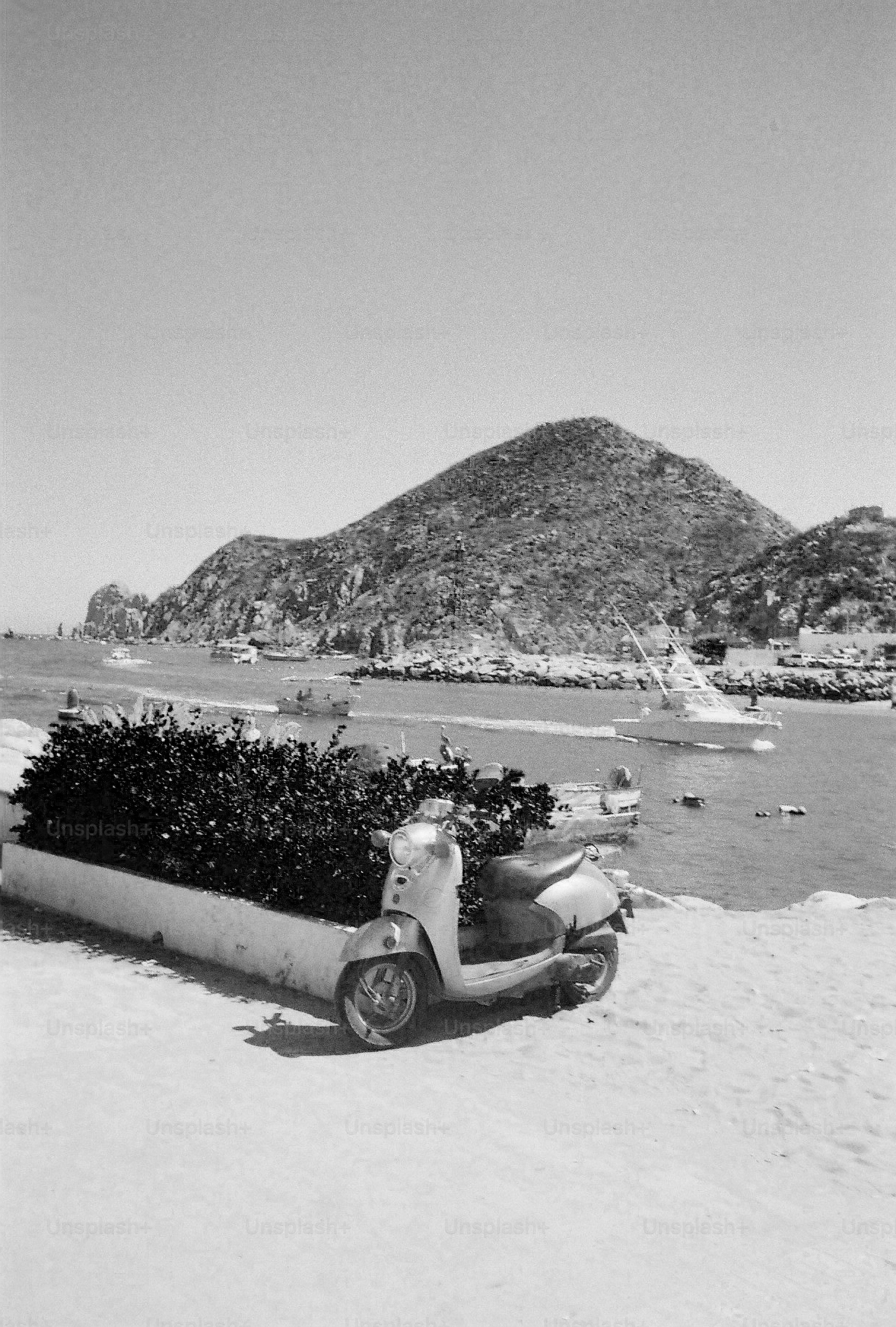 Scooter estacionado perto do porto com barcos e montanha