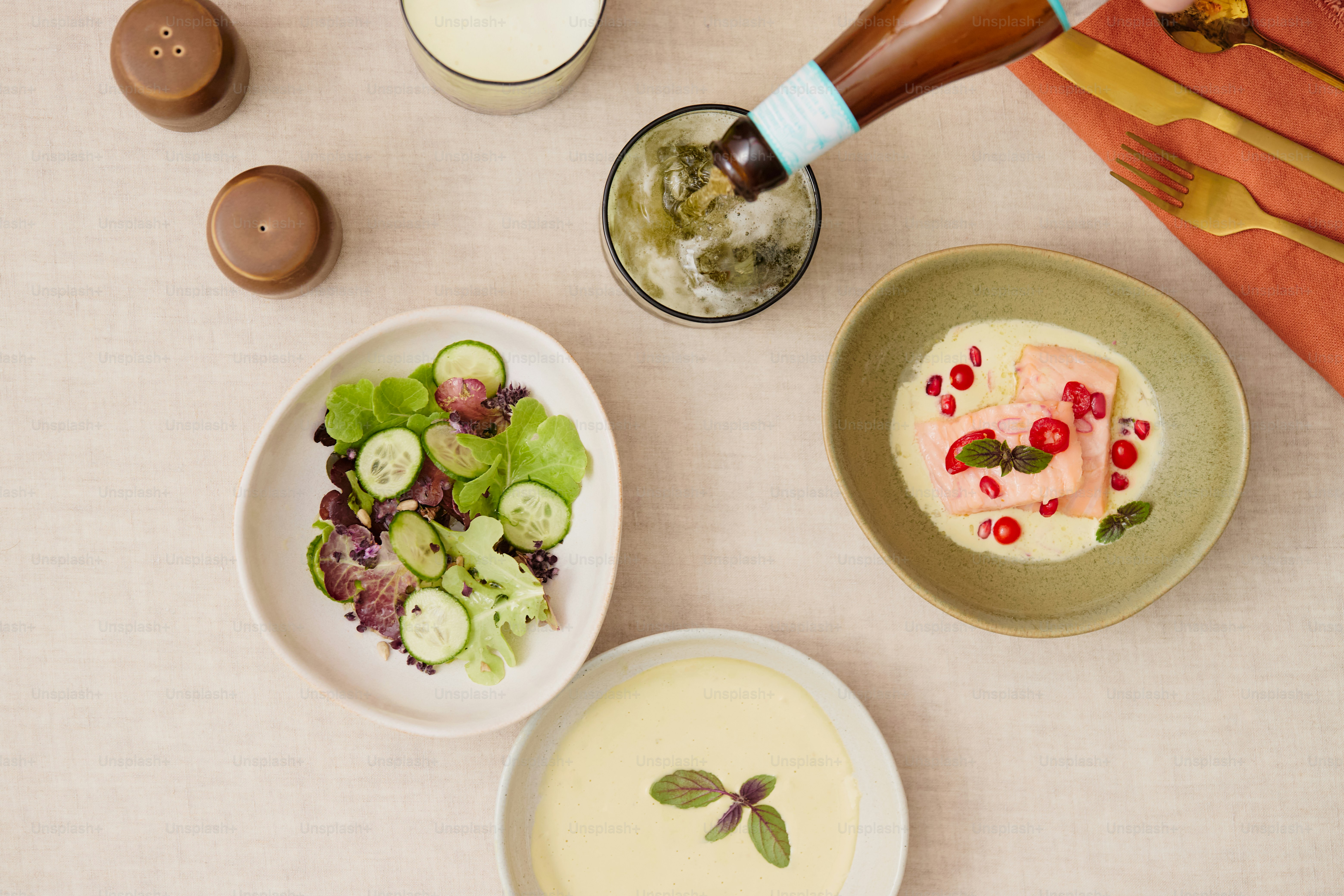 Piatto di salmone, insalata, zuppa e bevanda versati sul tavolo