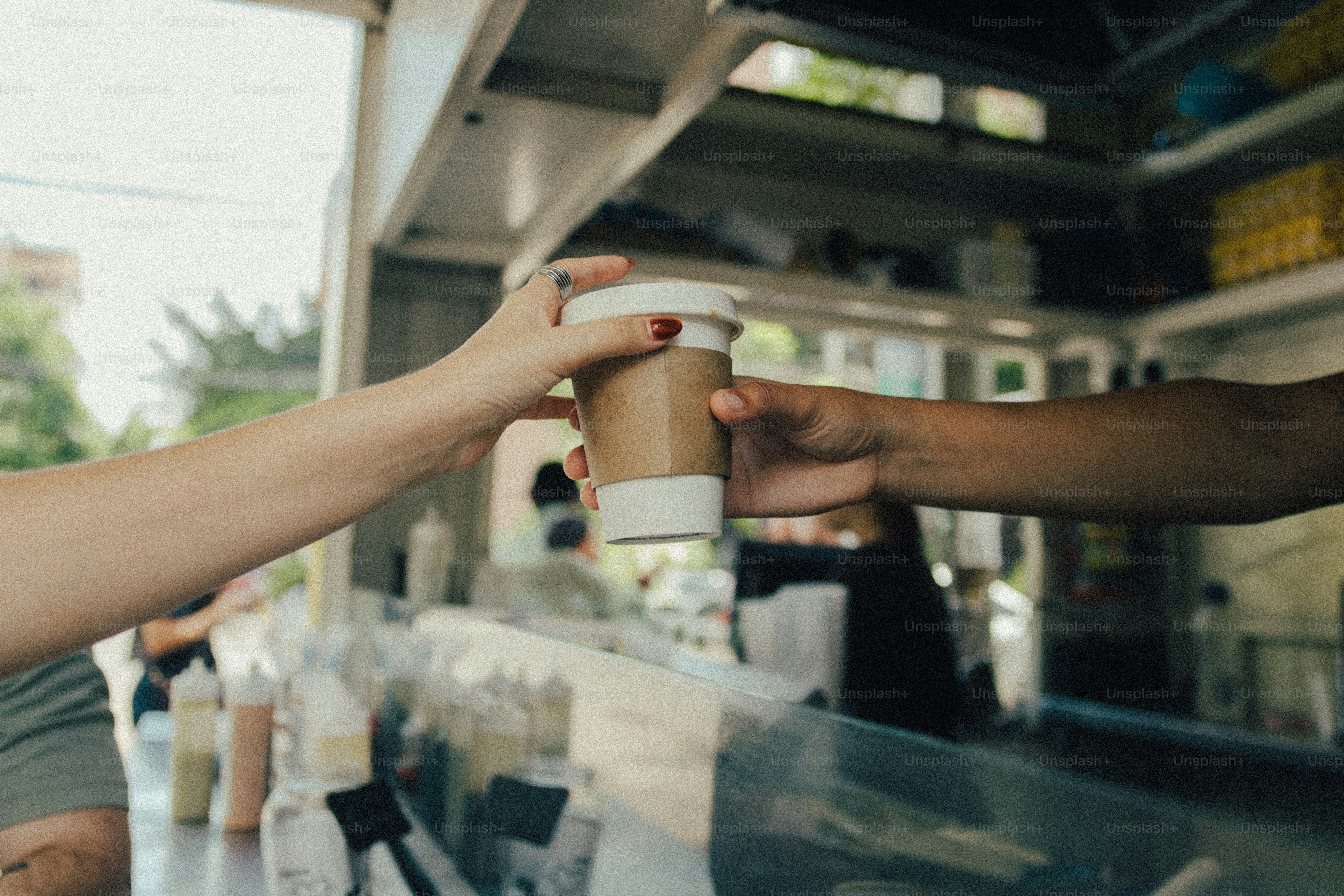 Hands exchanging coffee cup from food truck