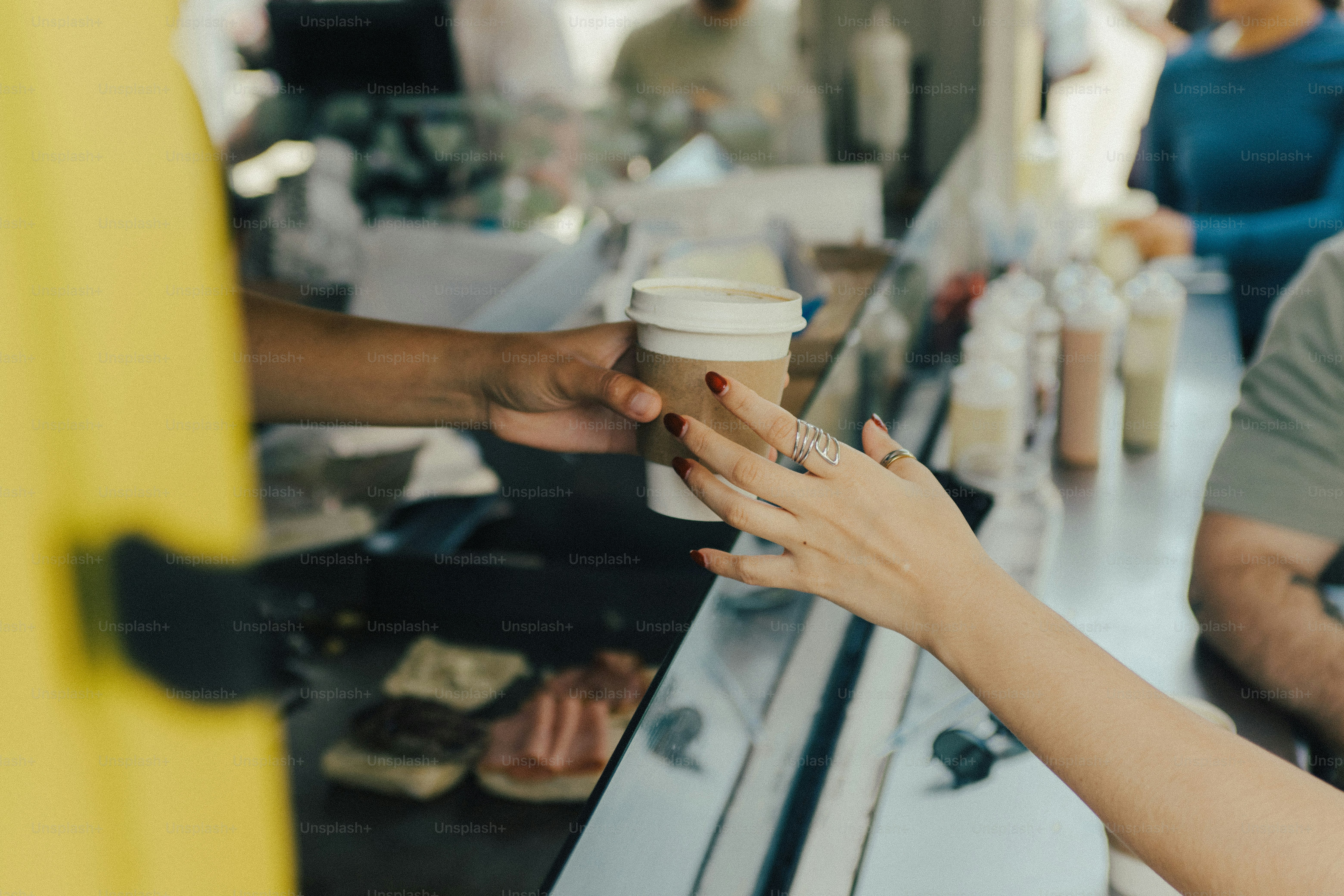Hands exchanging a coffee cup at a food stall