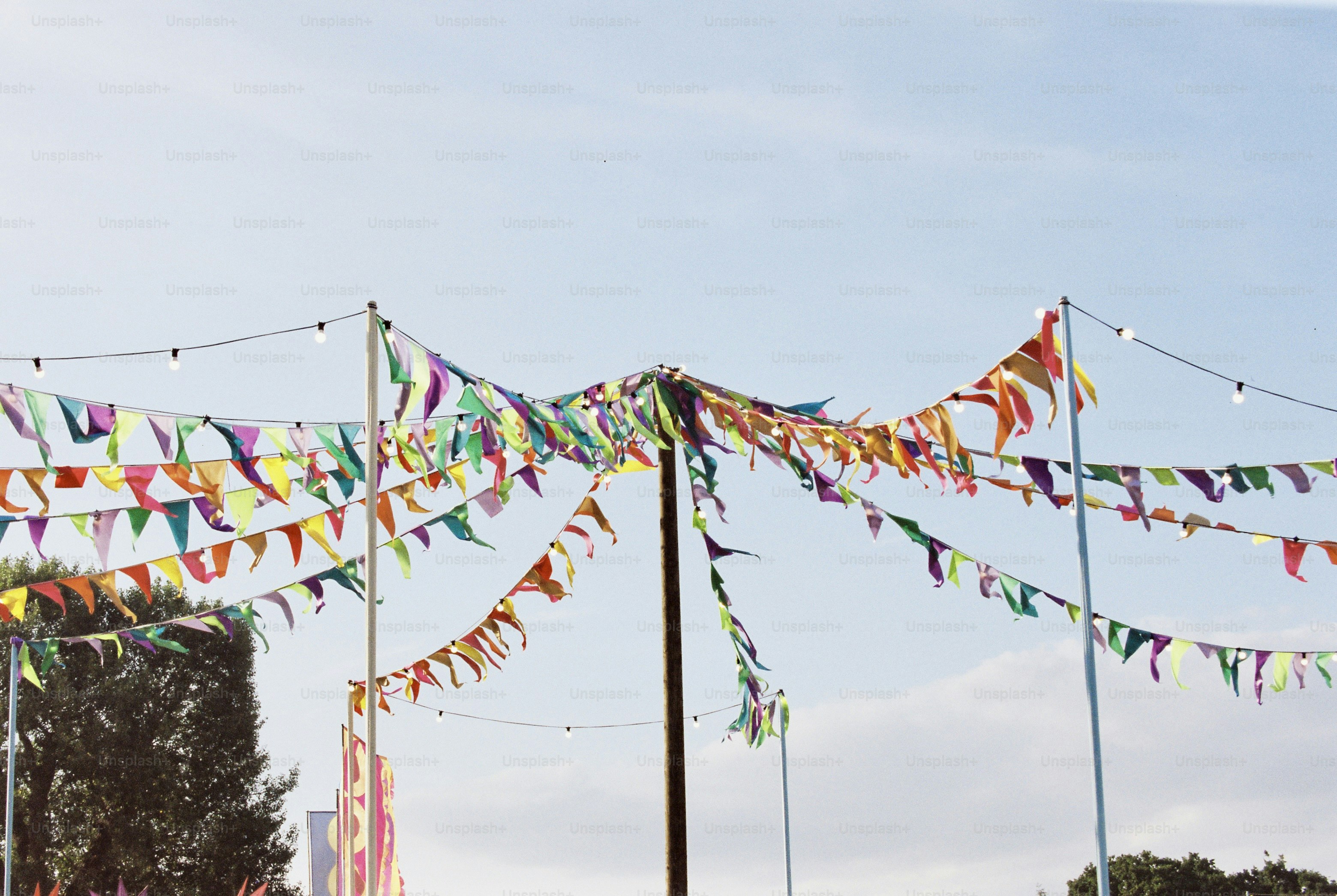 Colorful bunting and lights canopy against blue sky