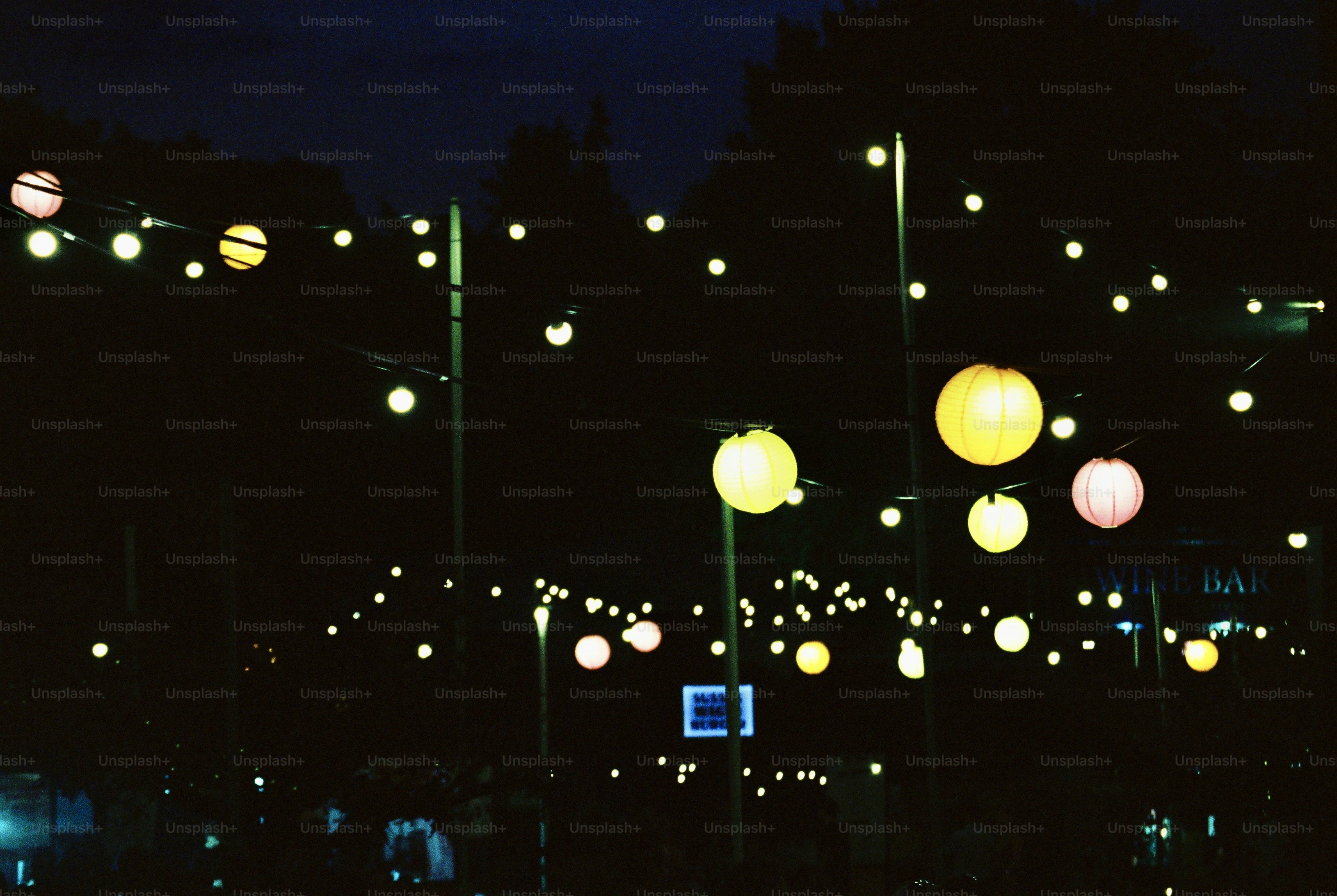 Colorful lanterns strung across a dark night sky