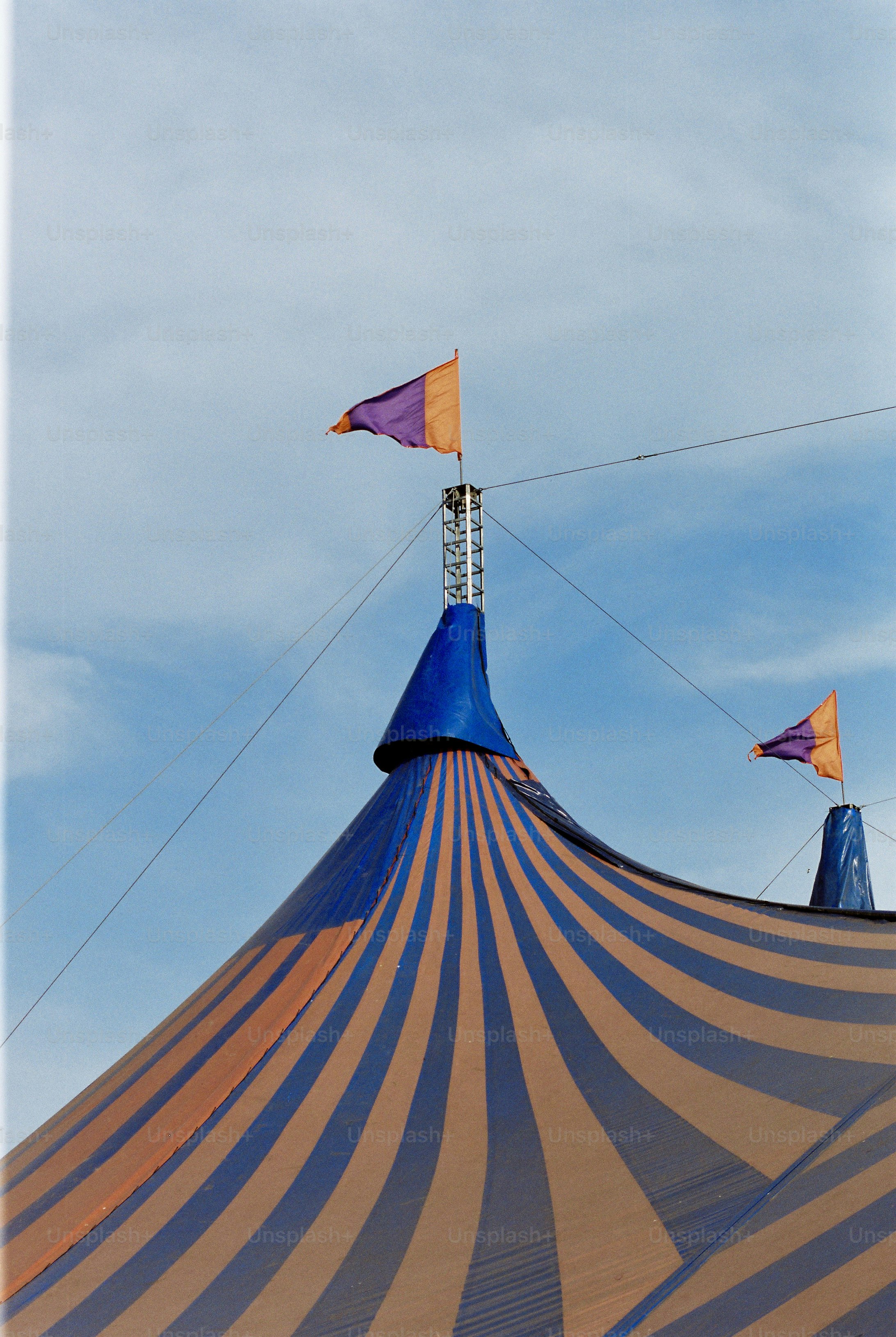 Blue and orange striped big top tent, pennant, clear sky