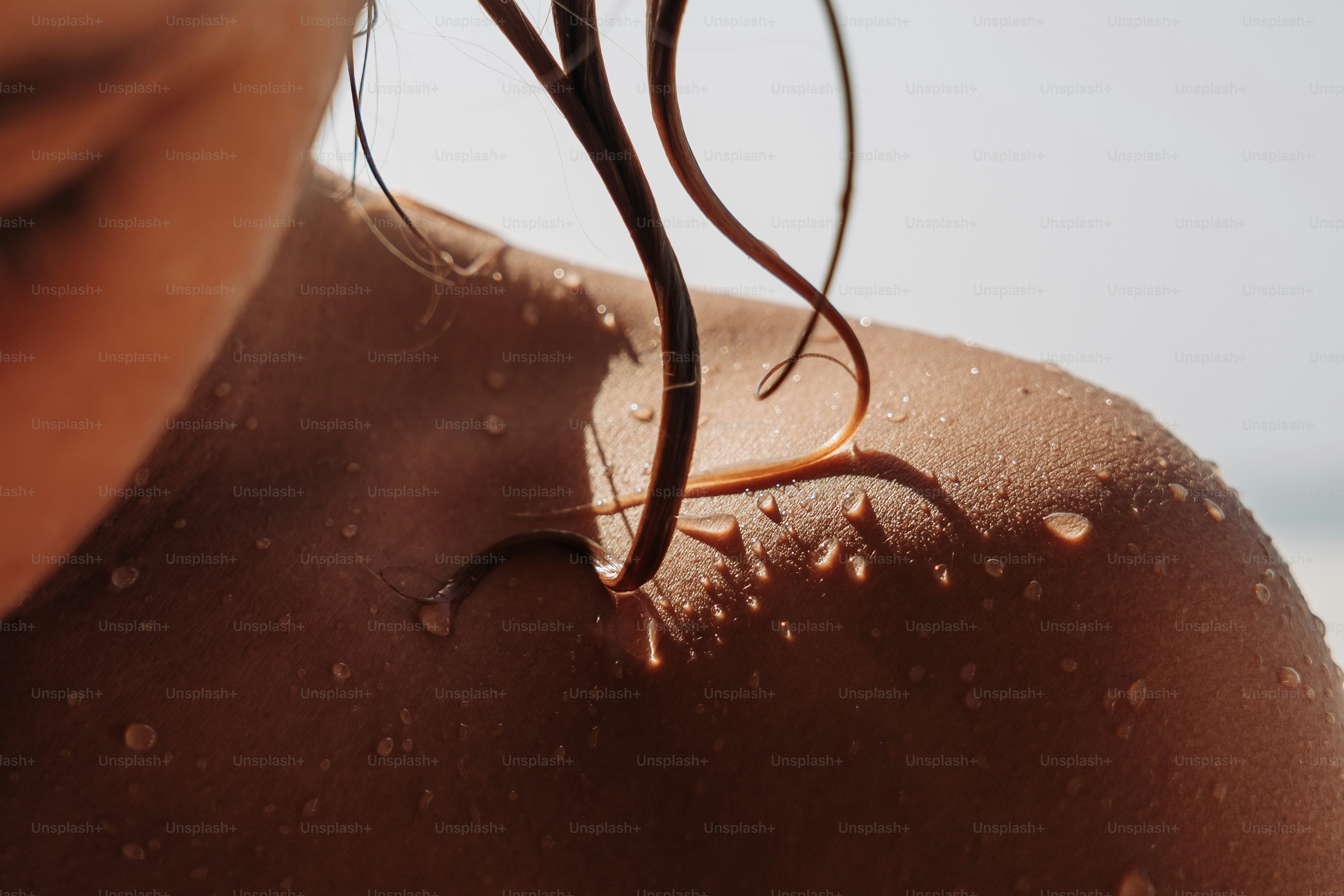 Nasse Schulter und Haare mit glänzenden Wassertropfen