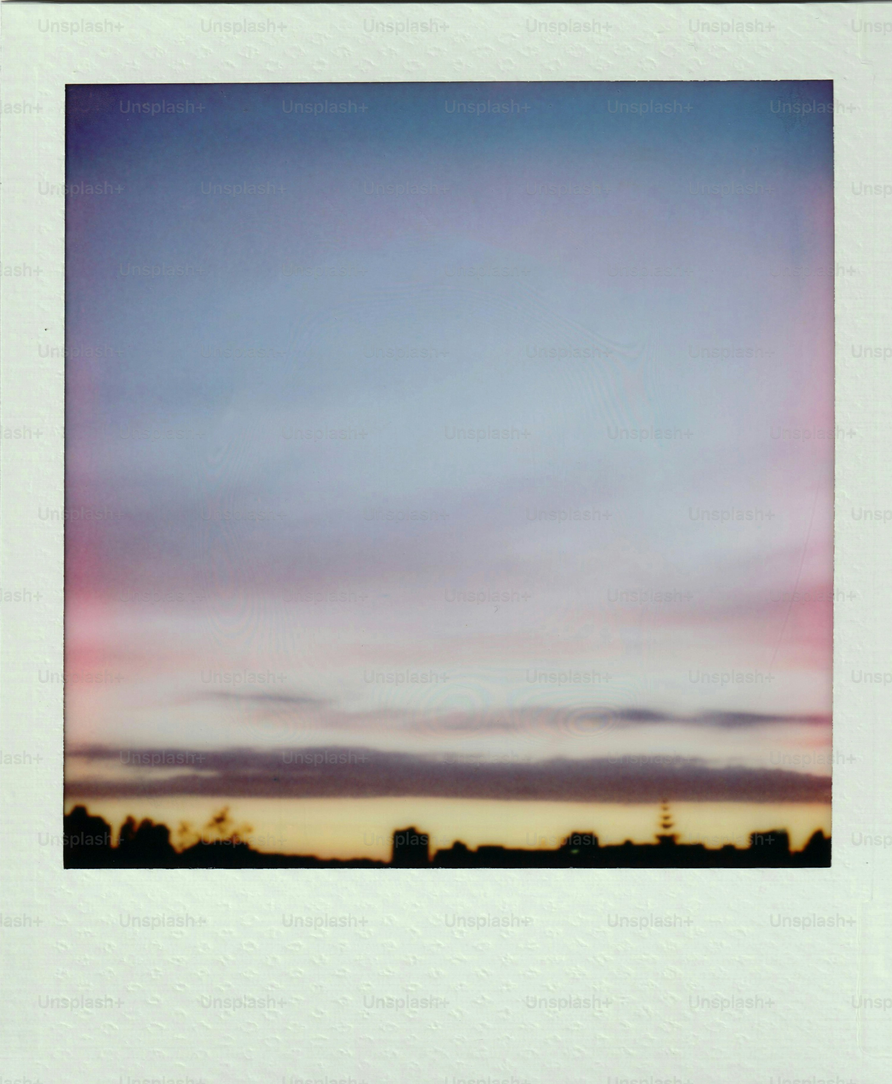 Ciel pastel couchant de soleil sur une silhouette floue de la ville