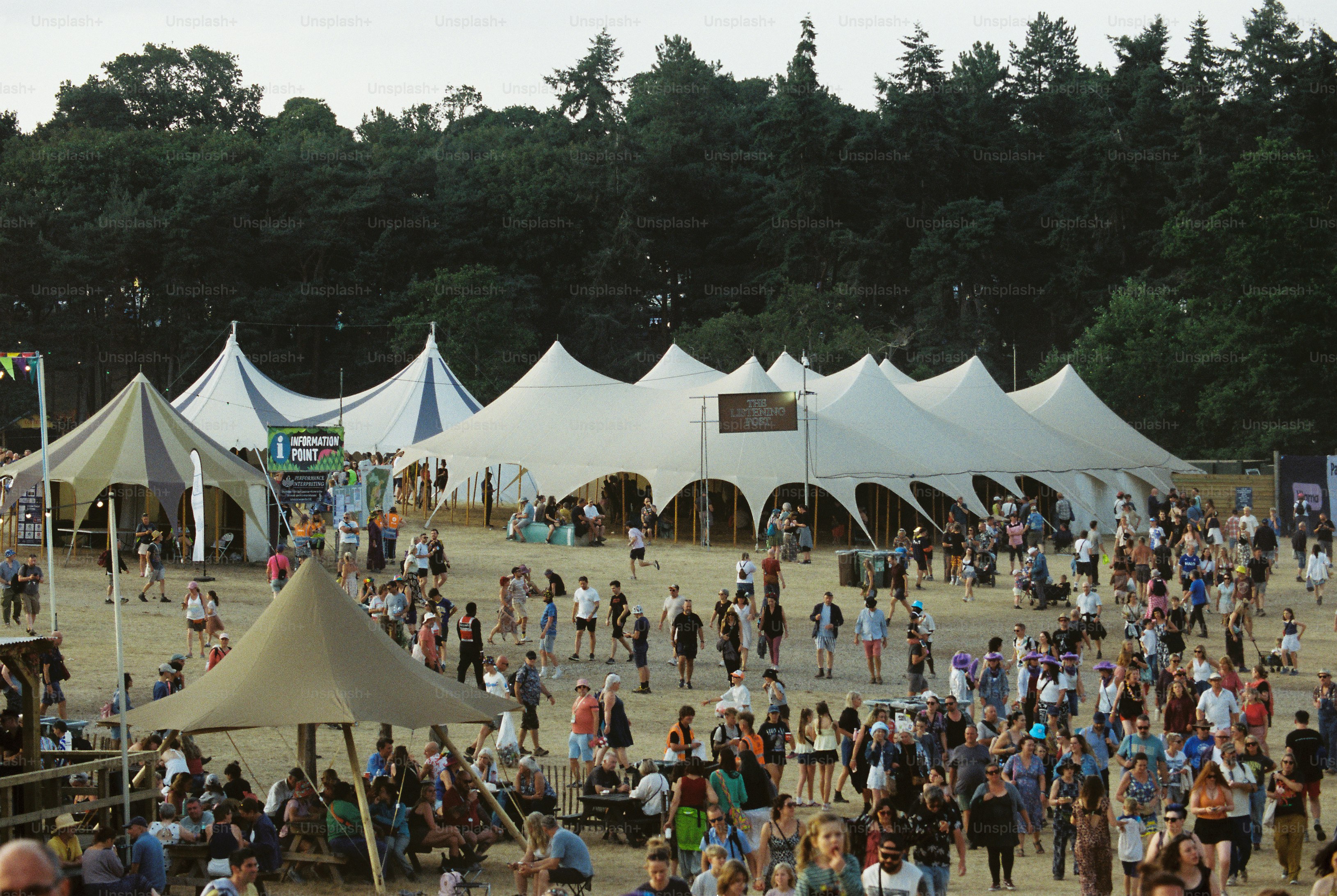 Les foules remplissent un terrain poussiéreux de festivals avec des chapeaux de chants en pointe