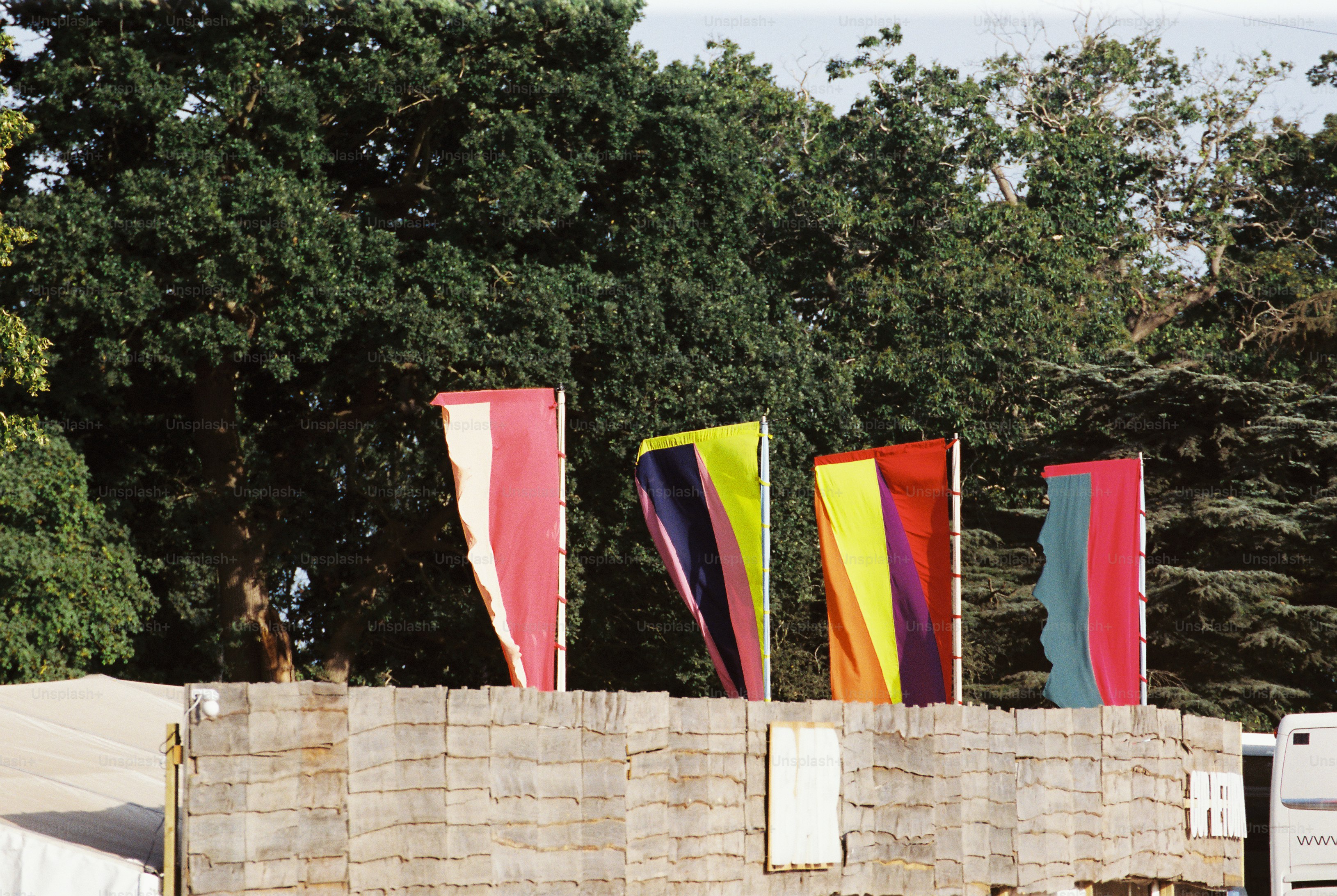 Quatre drapeaux audacieux sur le mur de jute avec des arbres verts
