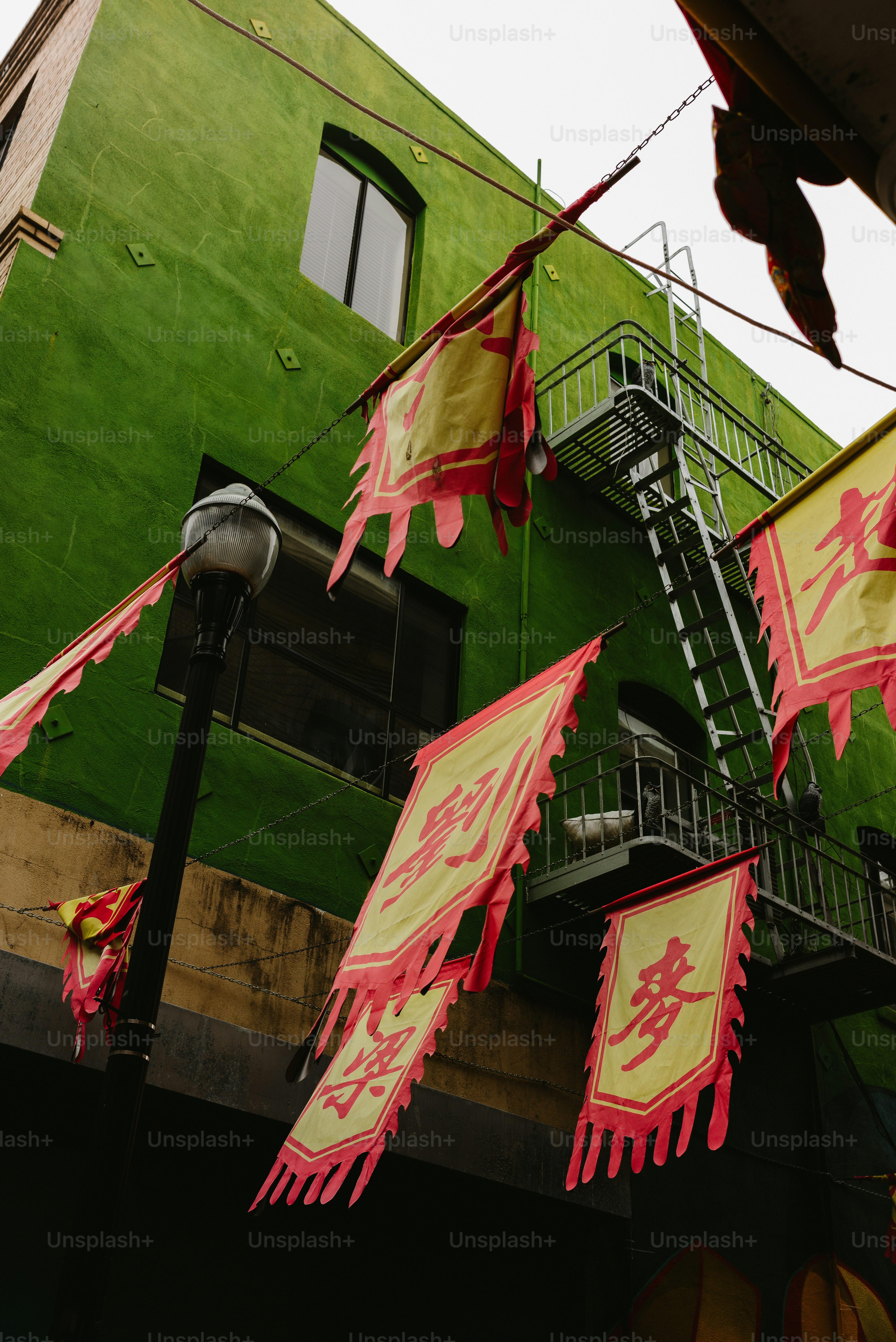 Asian banners hanging over an alley with green building