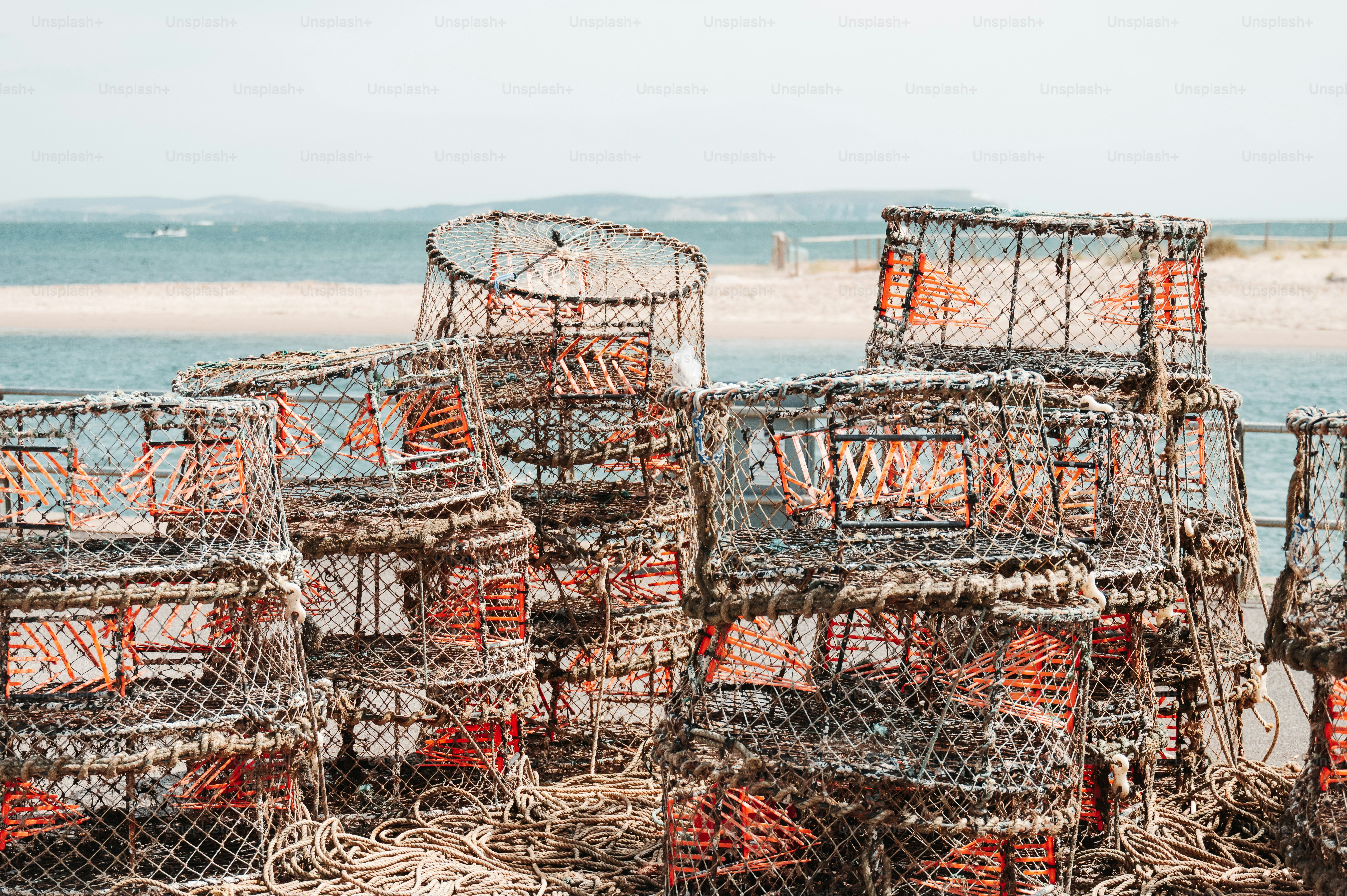 A stack of wire lobster pots on a pier by the sea