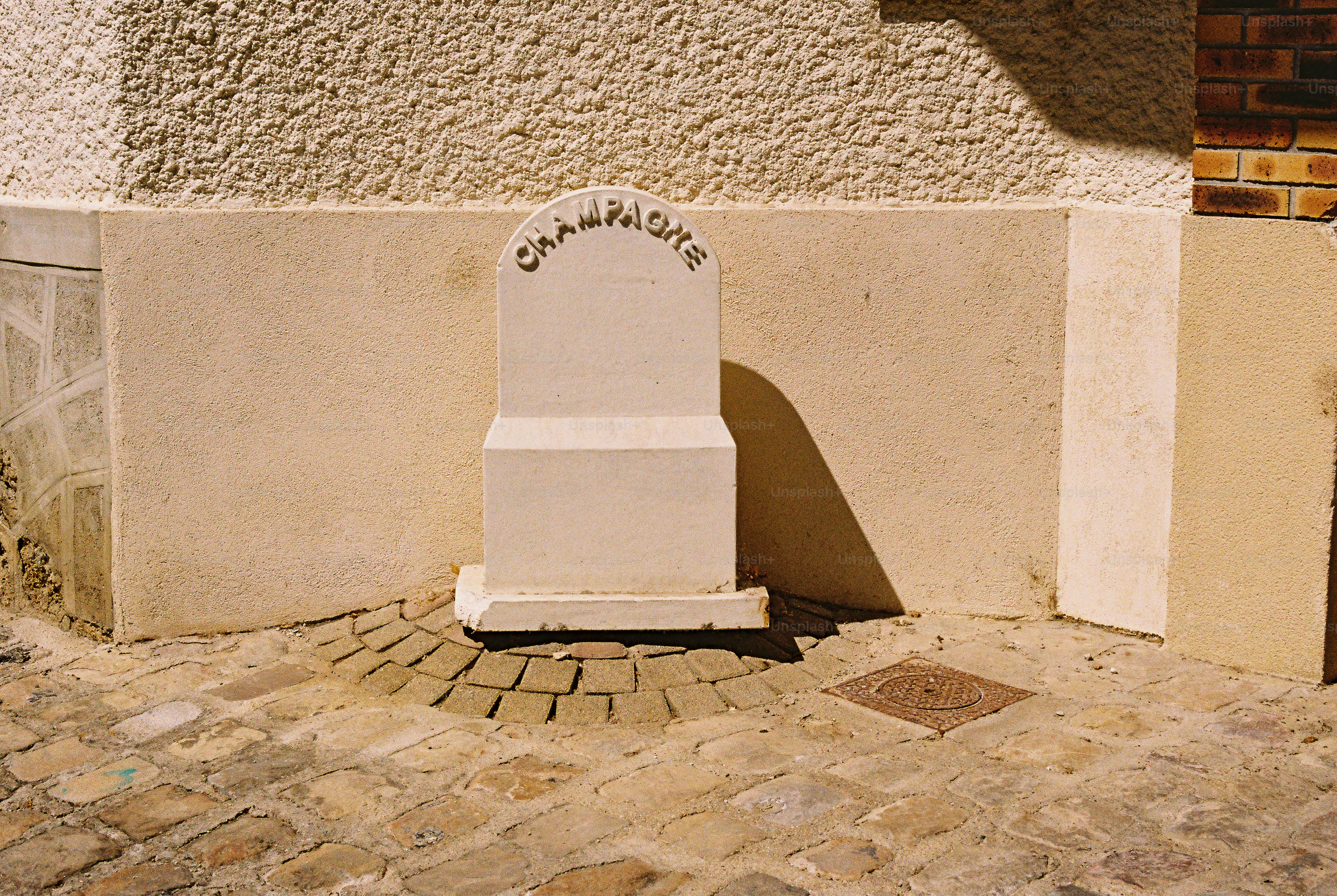 White stone marker inscribed champagne on cobbled street