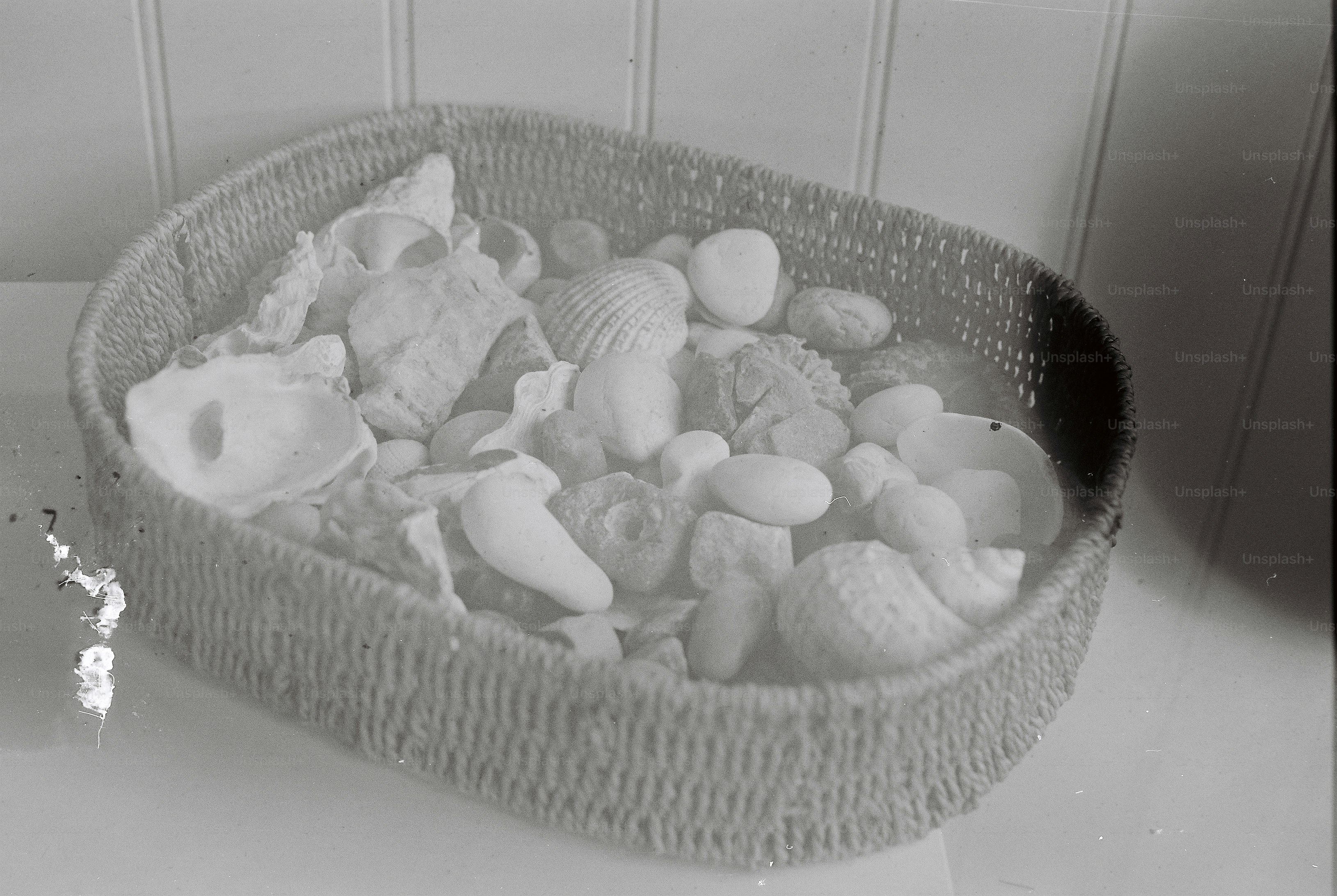 Woven basket filled with seashells and pebbles