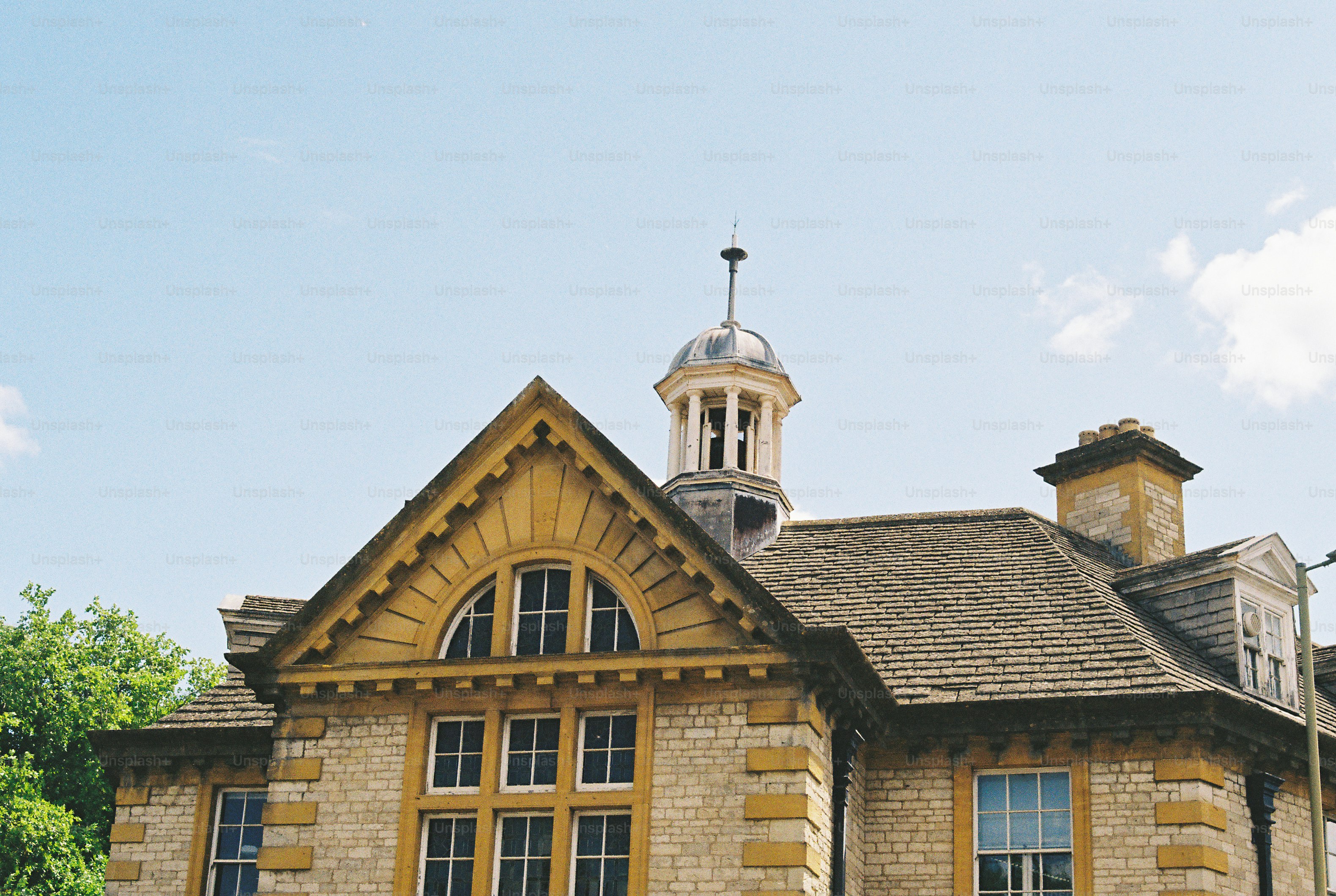 Yellow building with gabled roof and cupola