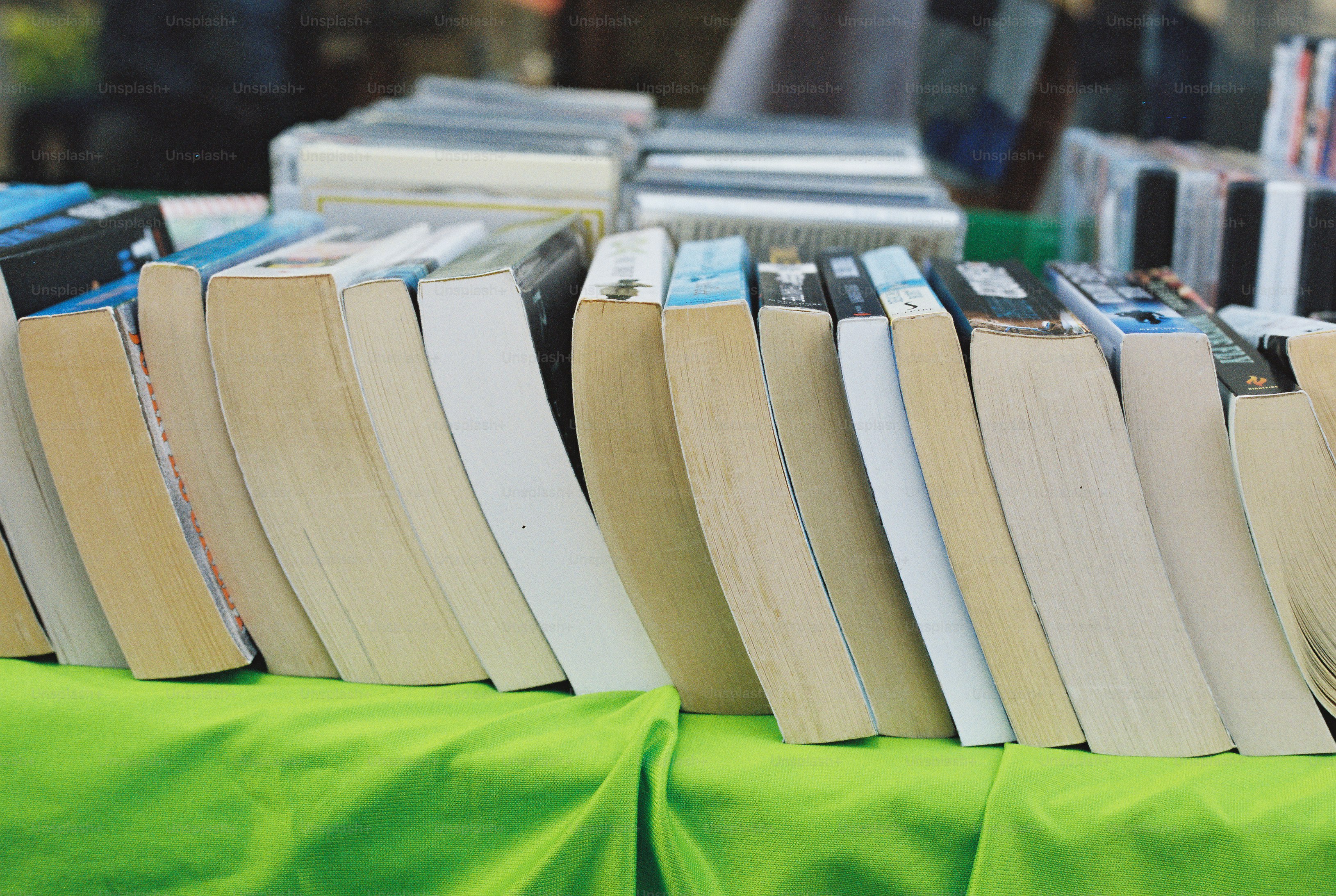 Books lined up on a vibrant green surface
