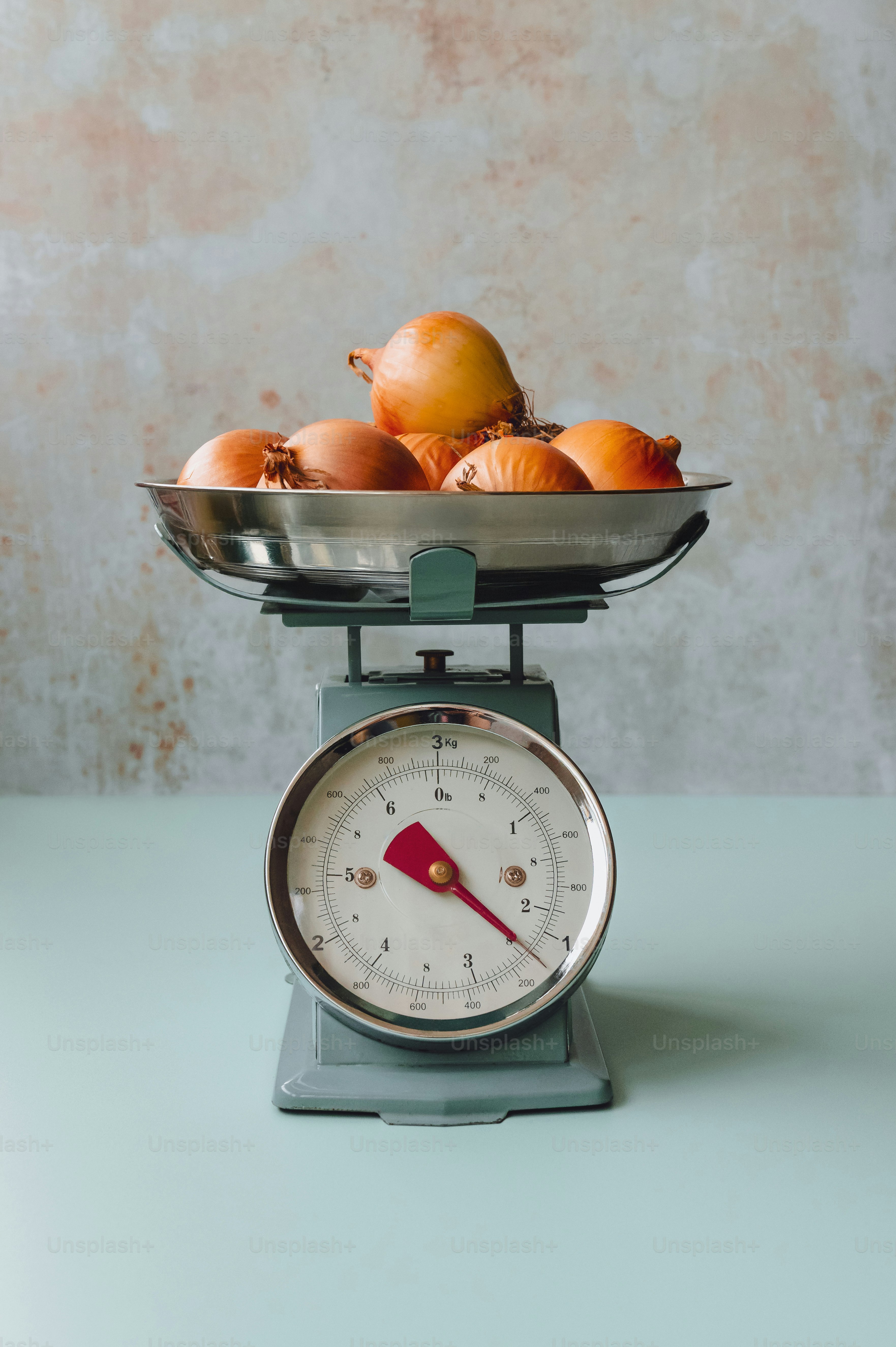 Des oignons frais pesant sur une balance rétro de cuisine