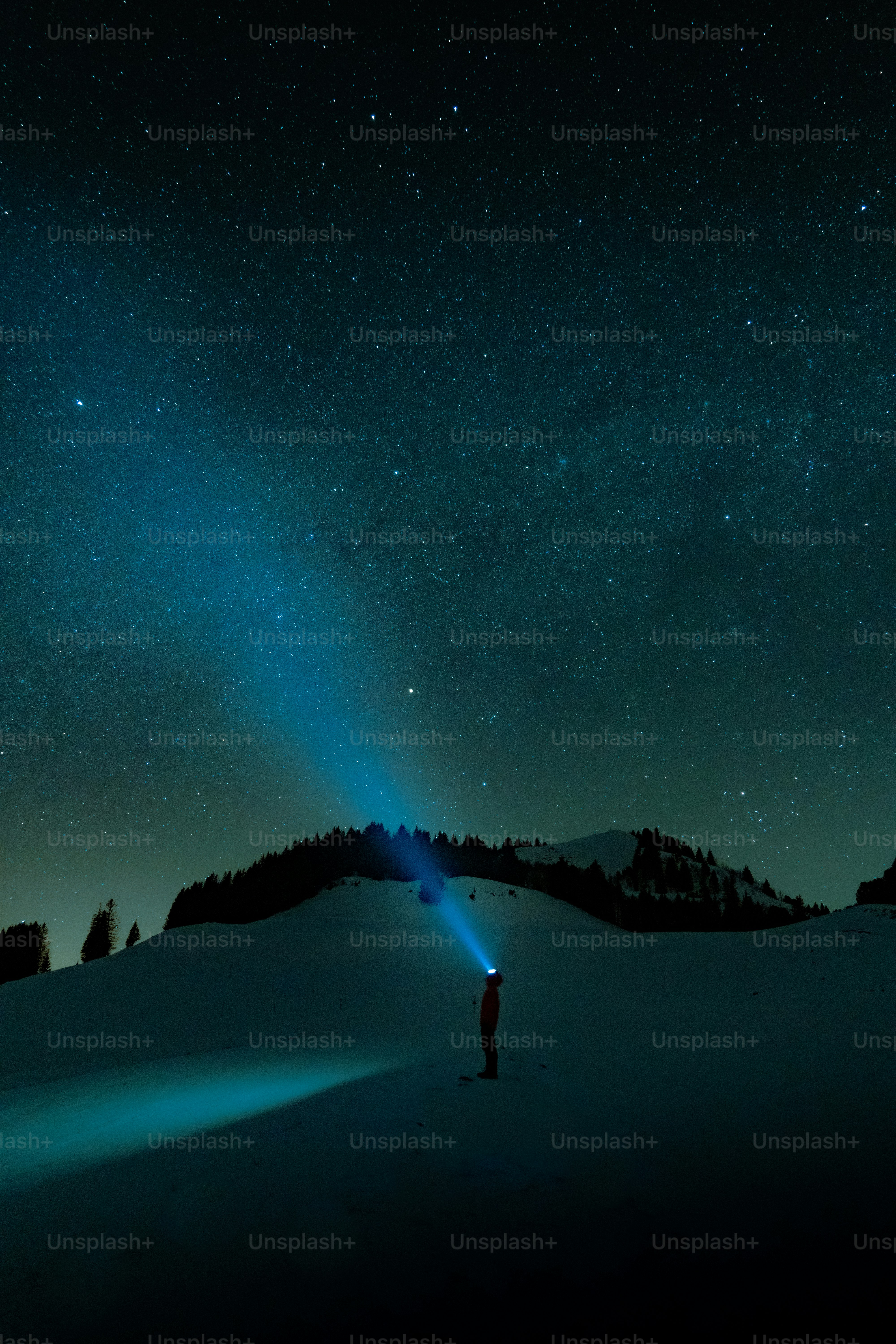 Person with flashlight under starry night sky