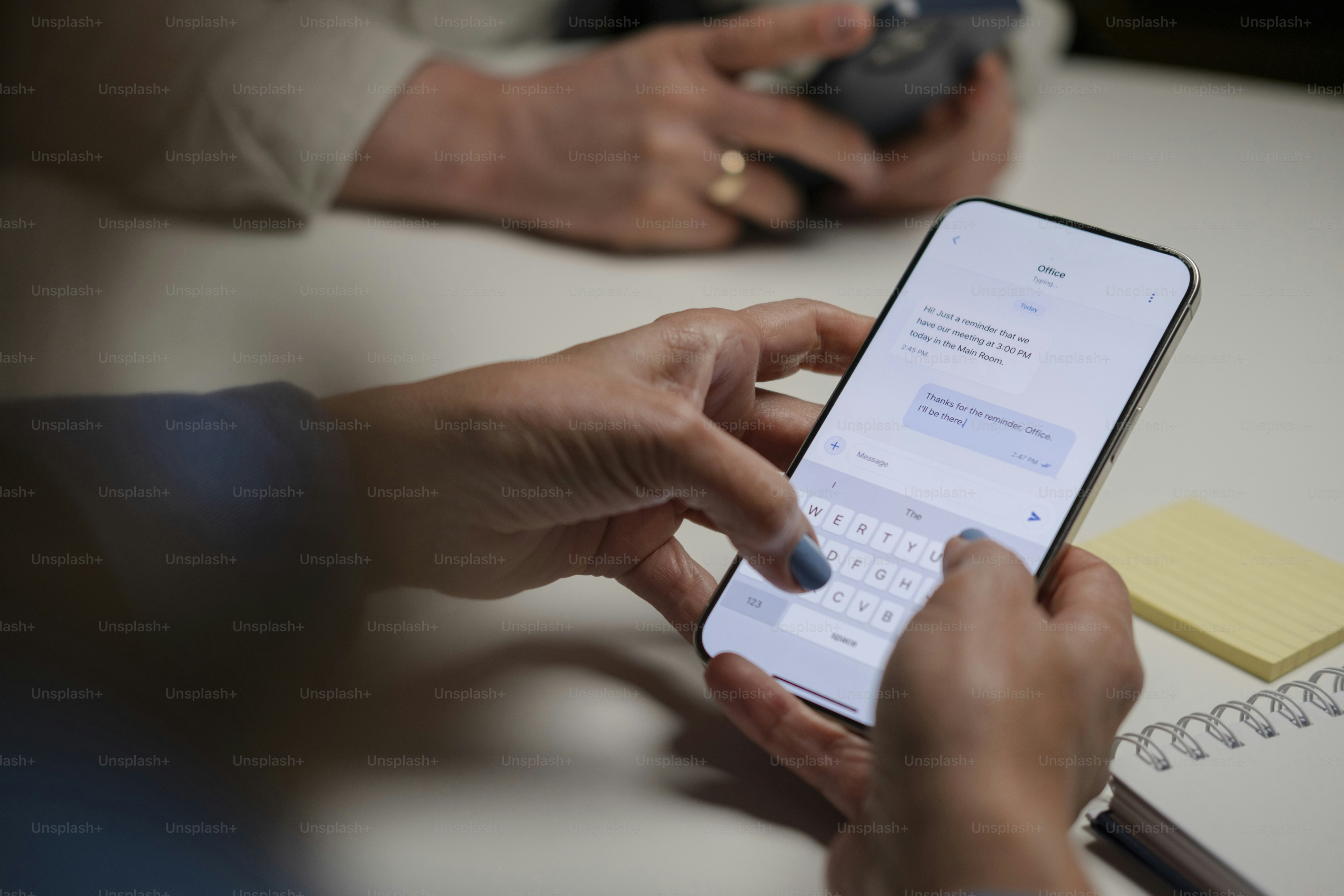 Mains en train de taper un message sur smartphone