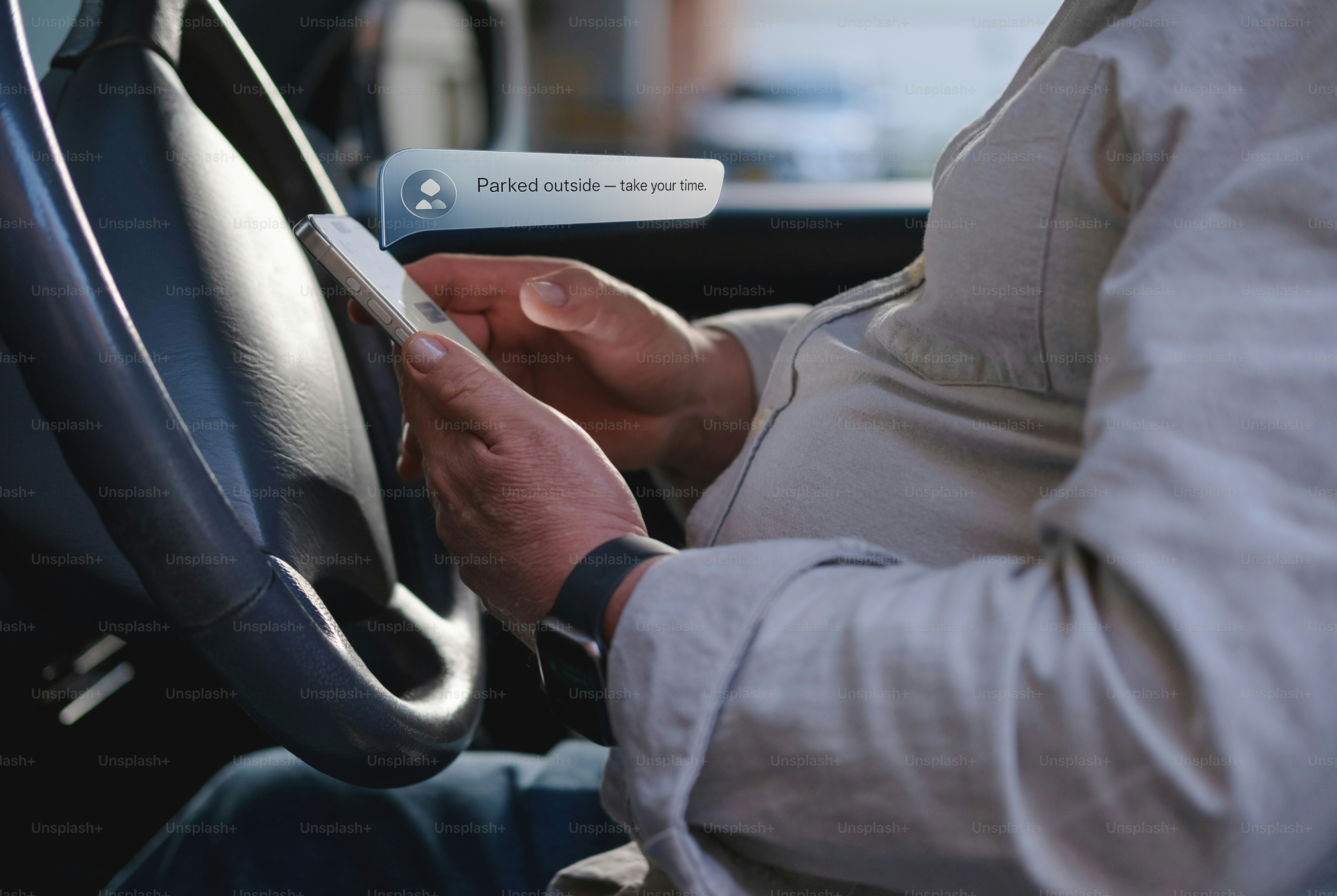 Mains tenant un smartphone à l’intérieur d’une voiture