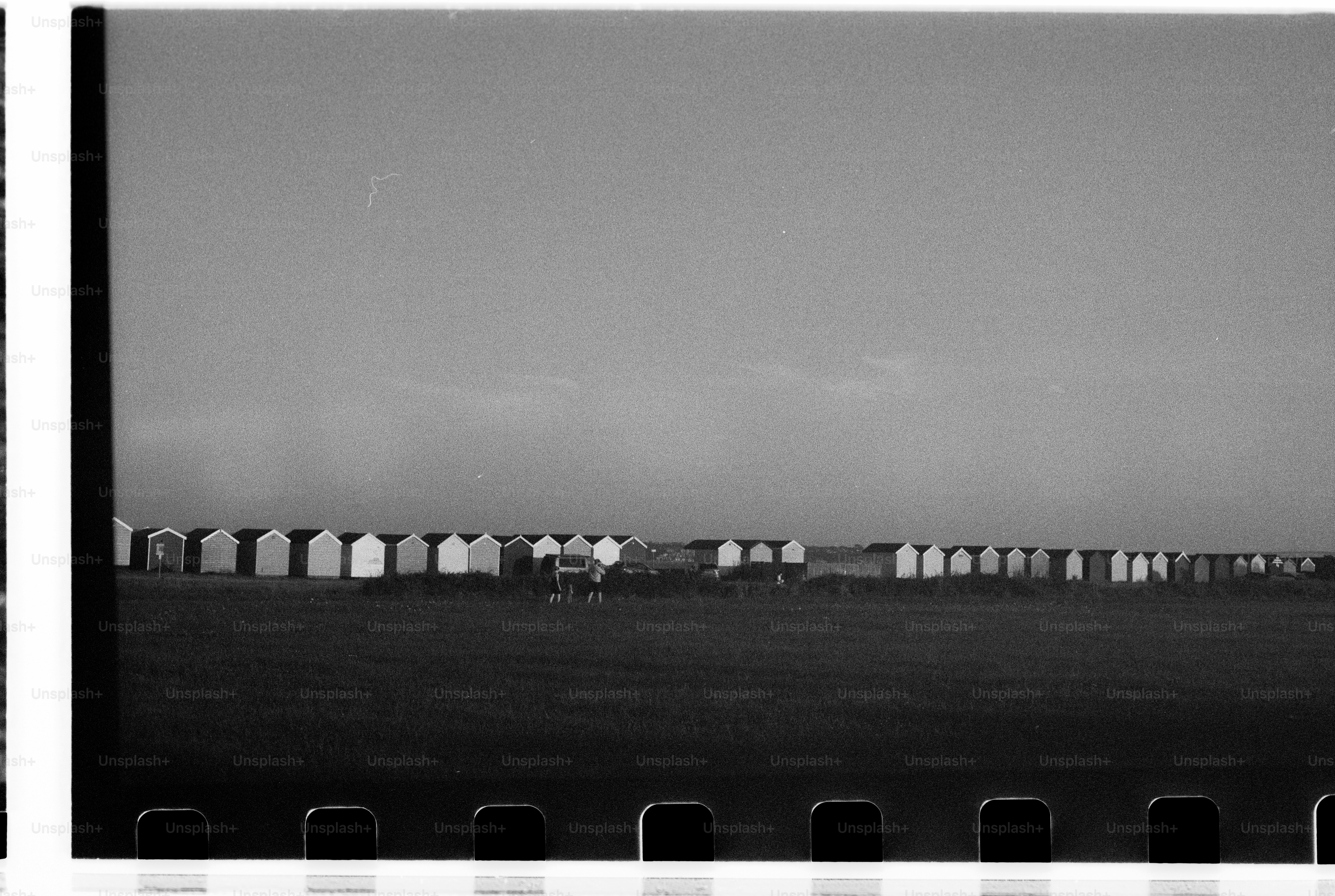 Monochrome beach huts lined on open field