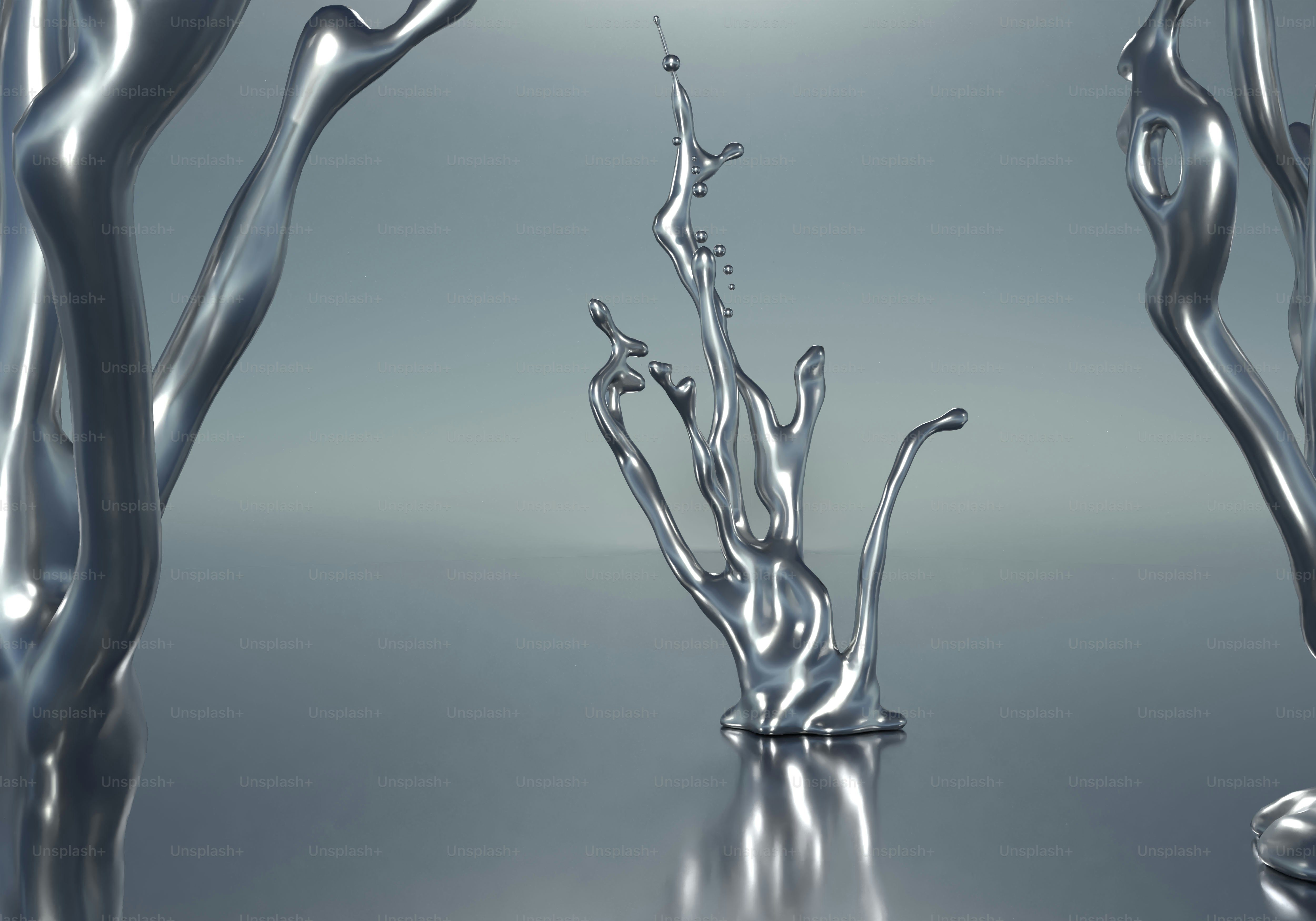 Abstract liquid metal forms on reflective grey surface
