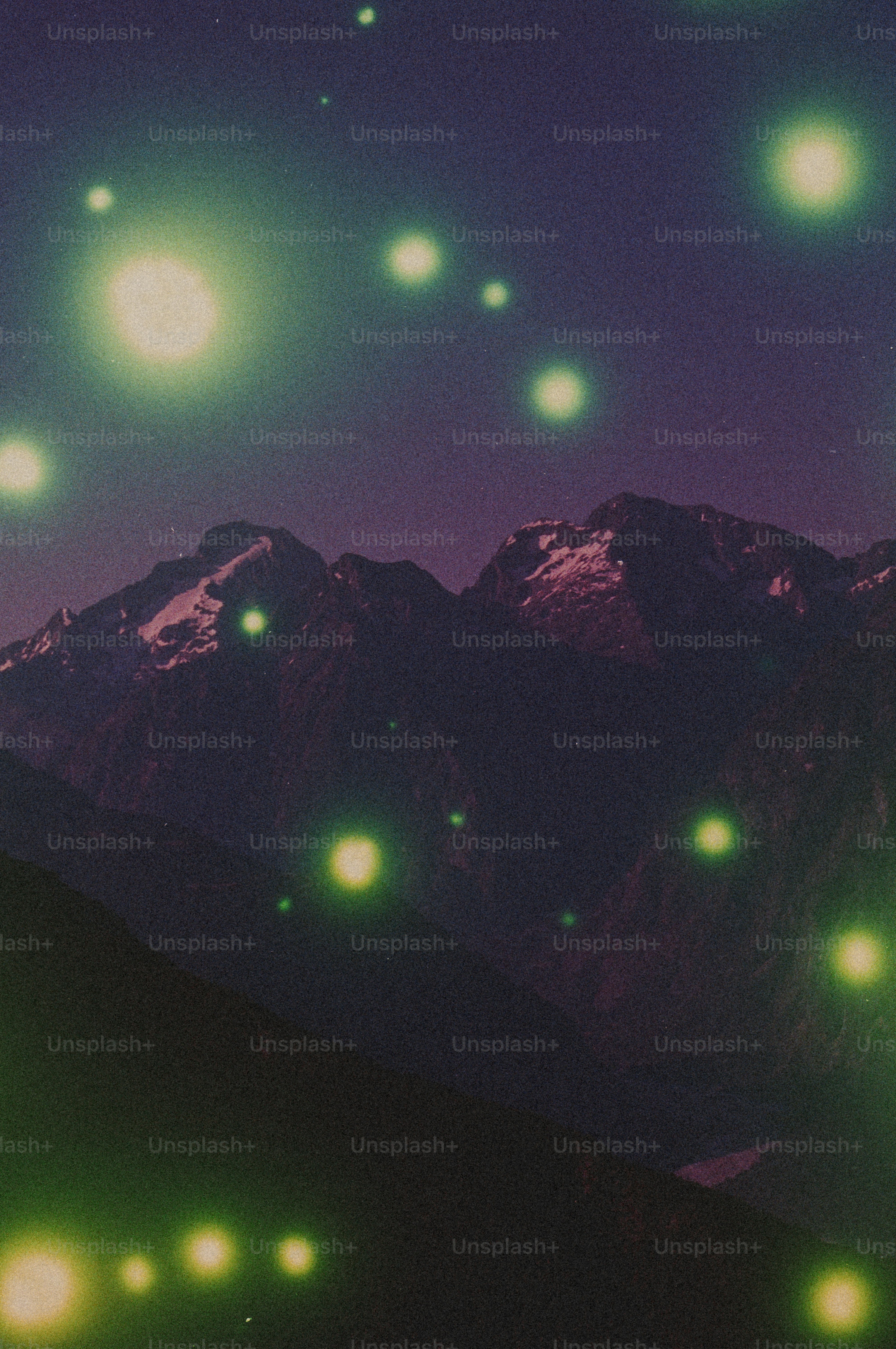 Green glowing orbs illuminate dark mountains at night