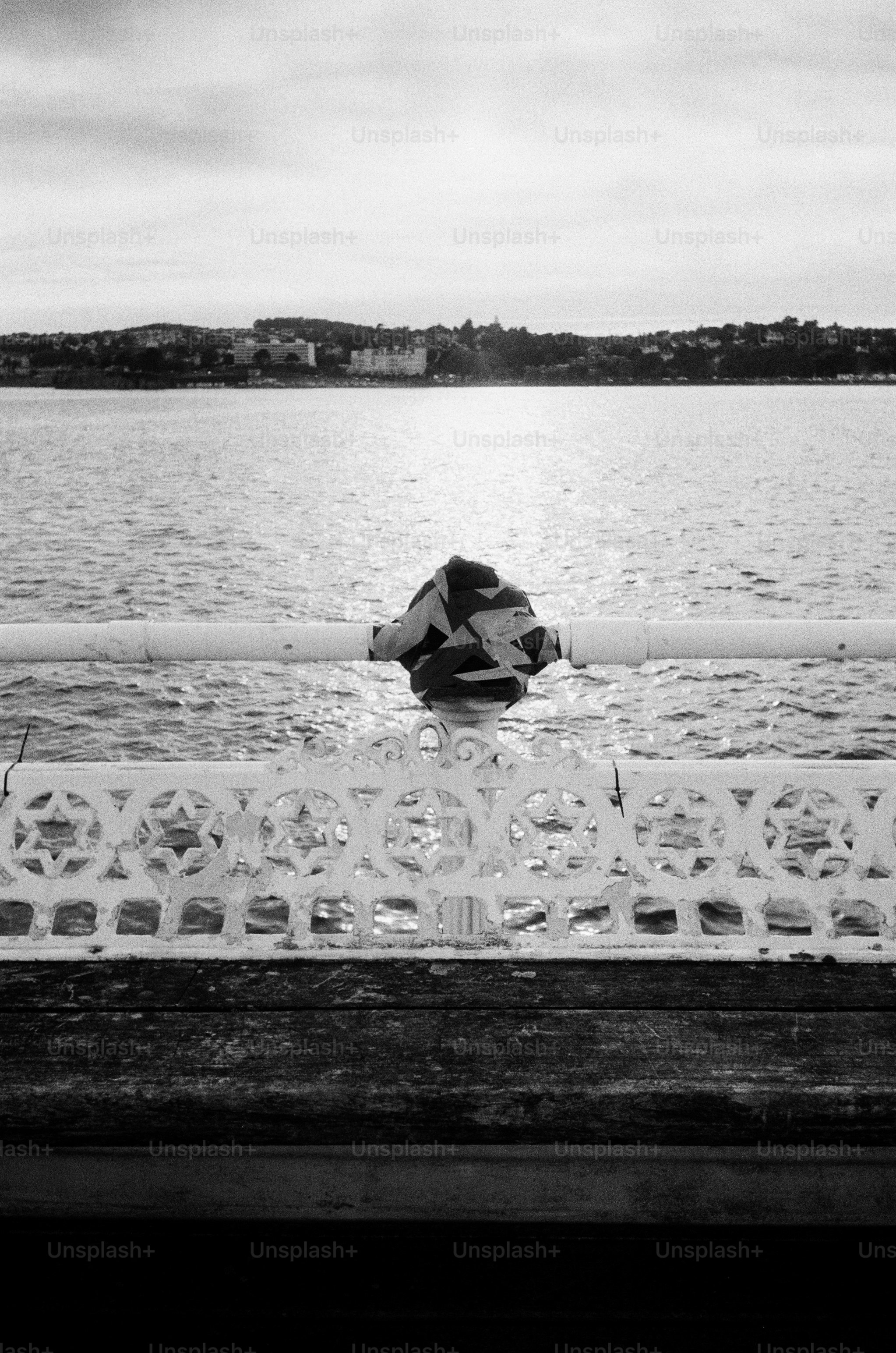 Deserted pier railing and bench overlooking water
