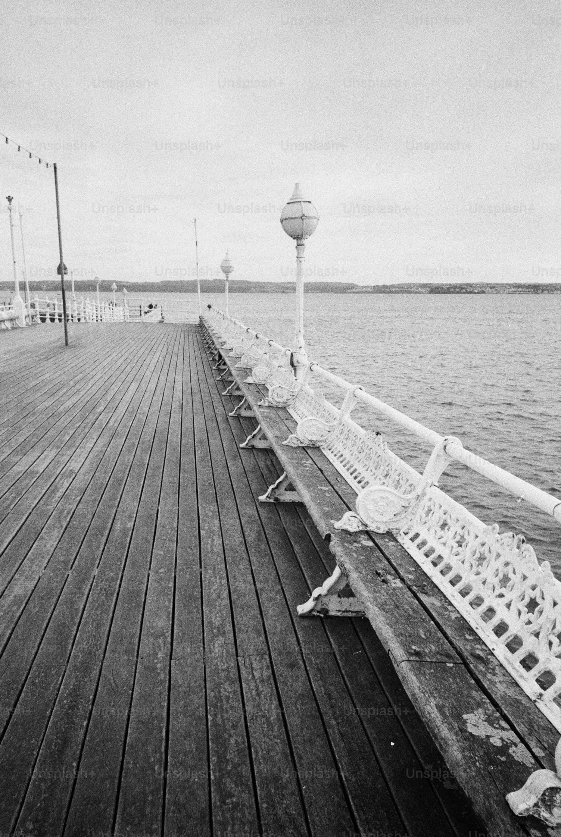 Deserted wooden pier with ornate benches.