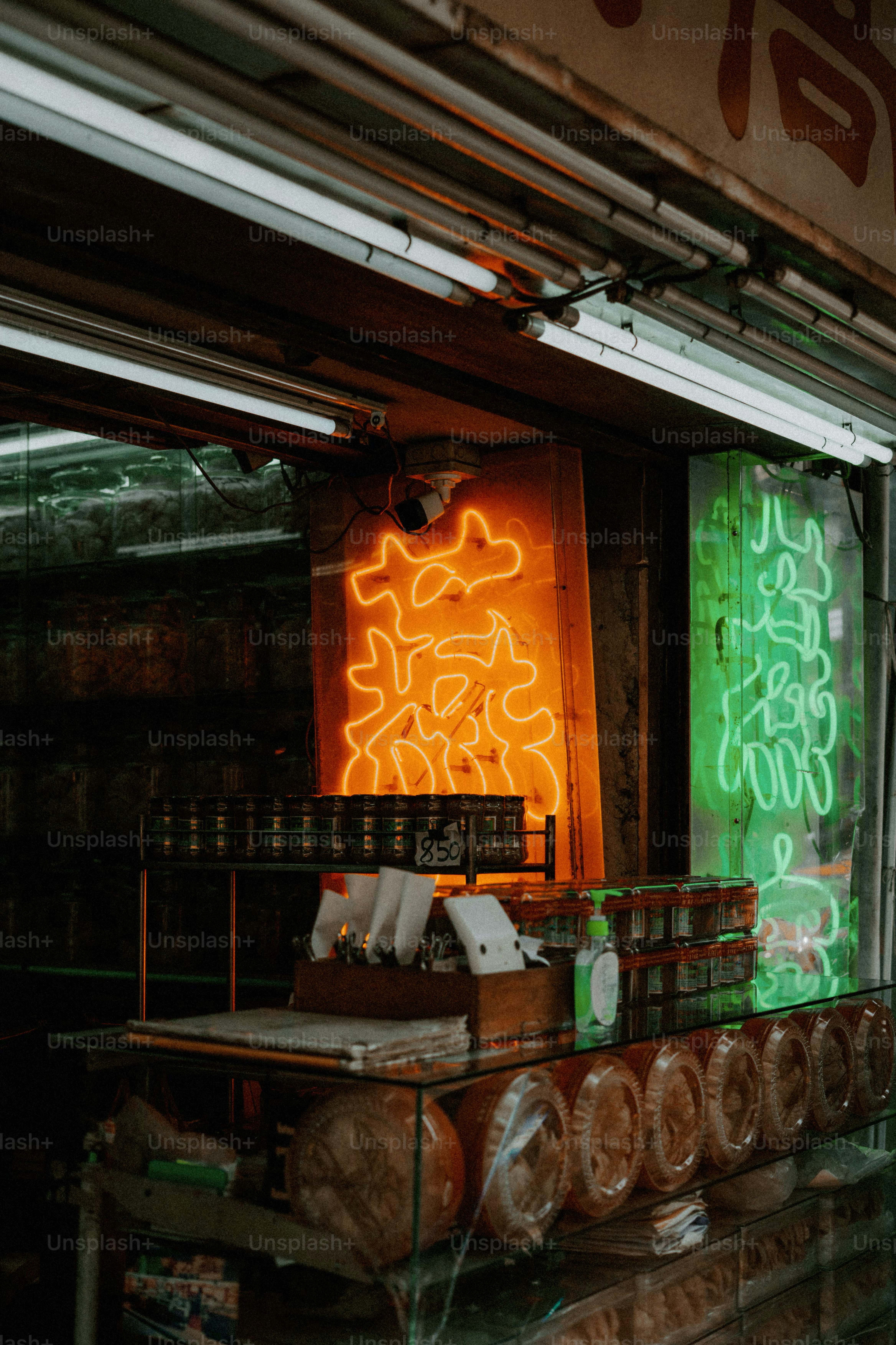 Orange and green neon signs with Chinese characters above a shop counter.