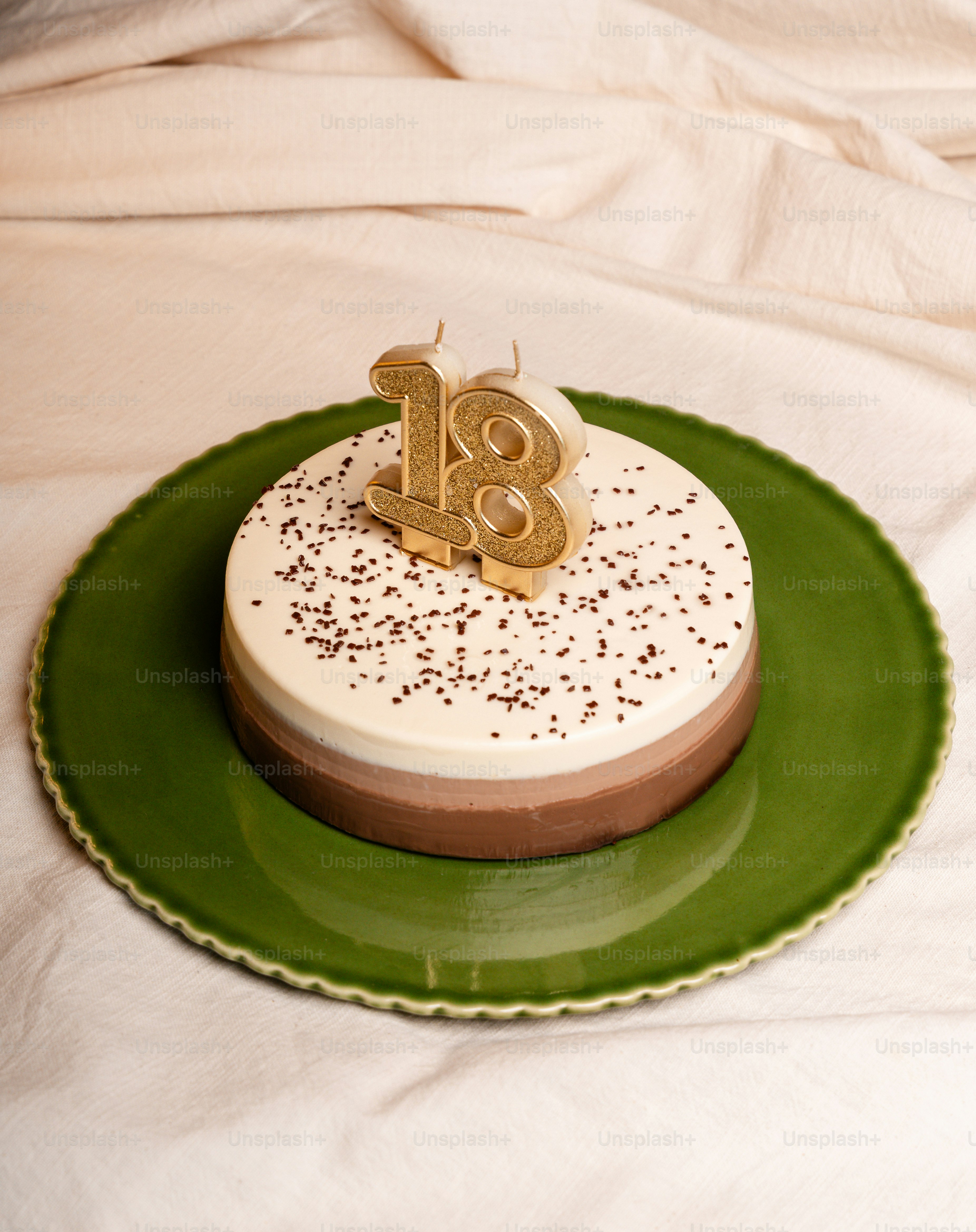 Layered birthday cake with "18" candle and sprinkles