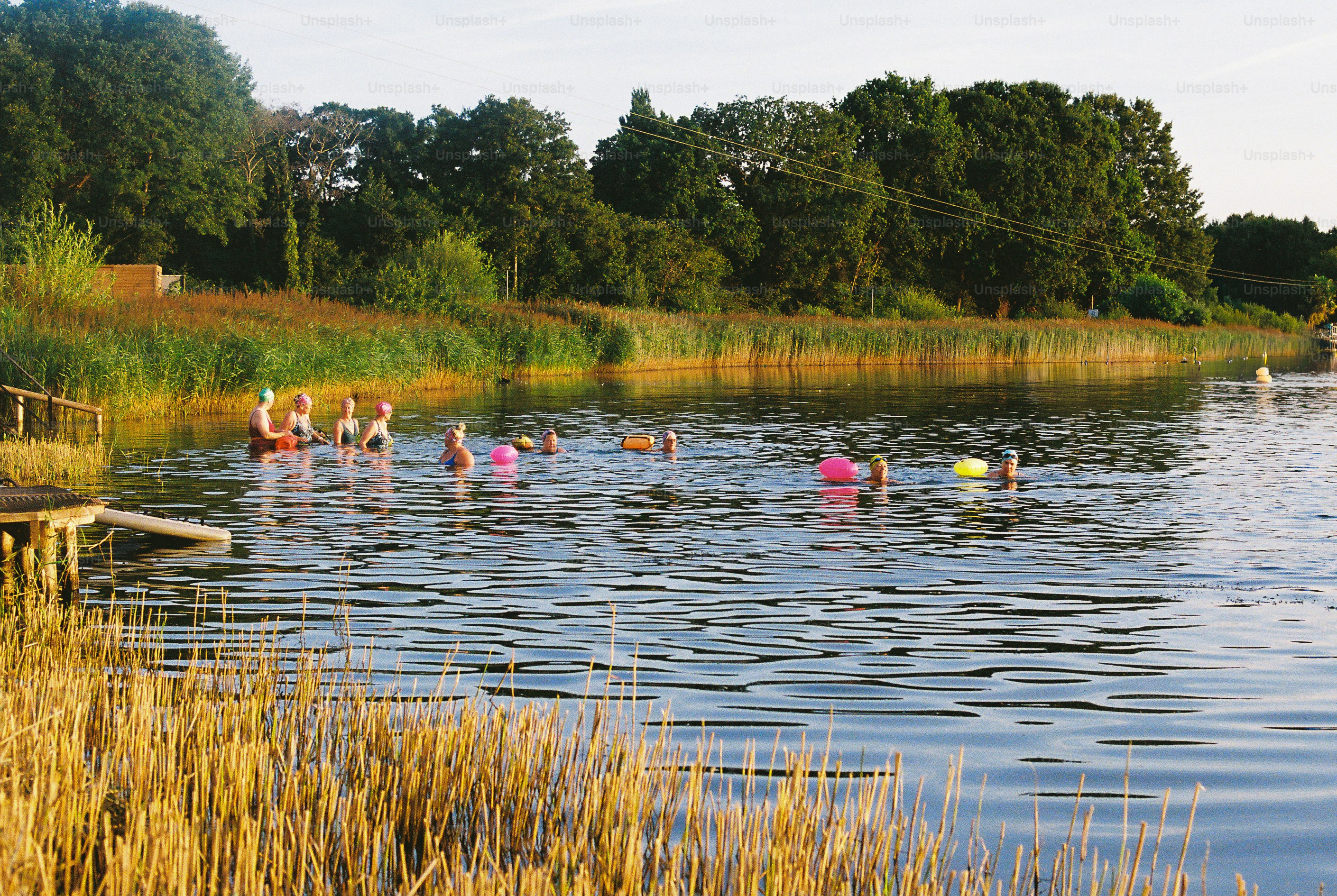 Swimmers with inflatables enjoying a calm lake