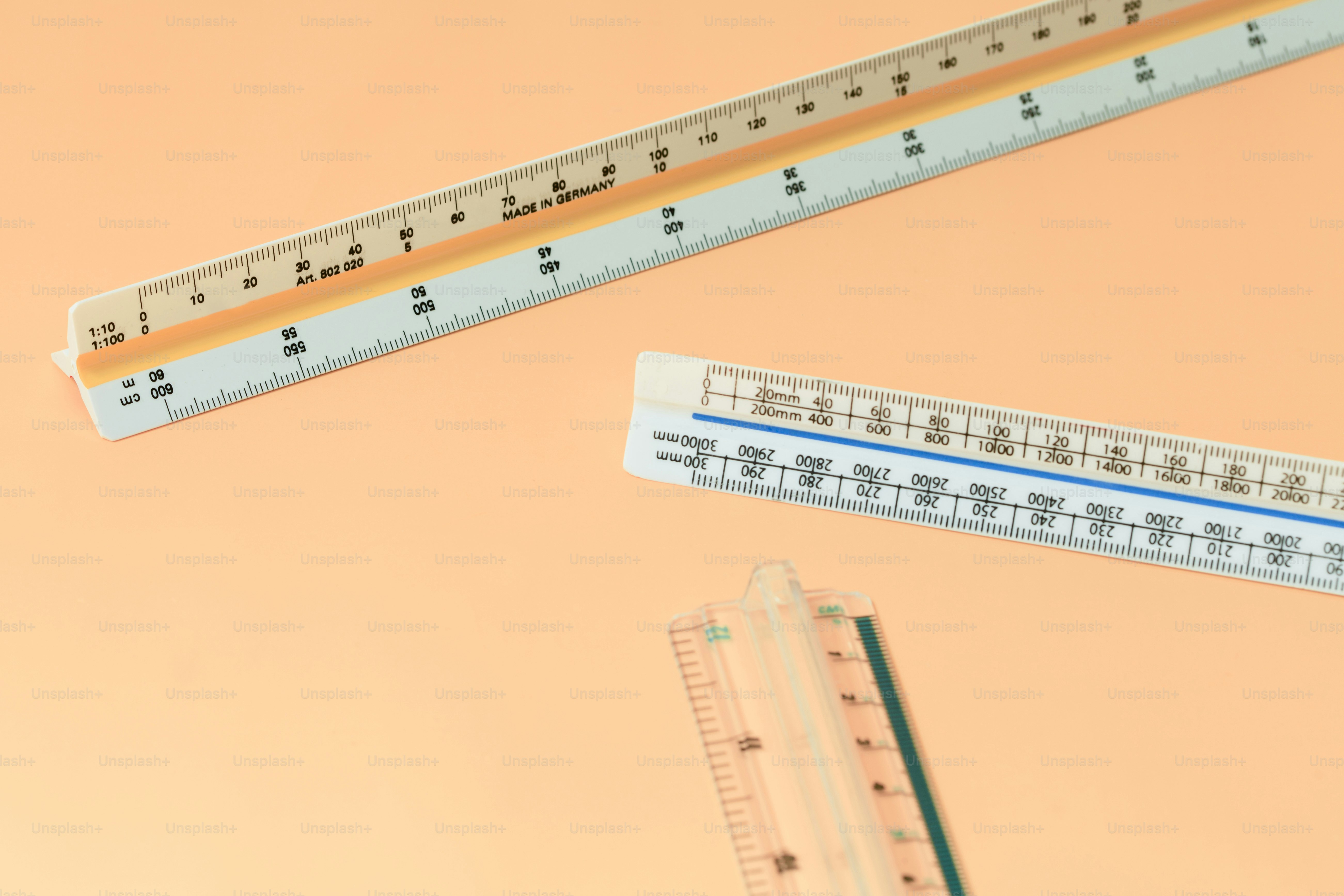 Three triangular architectural scales on orange background