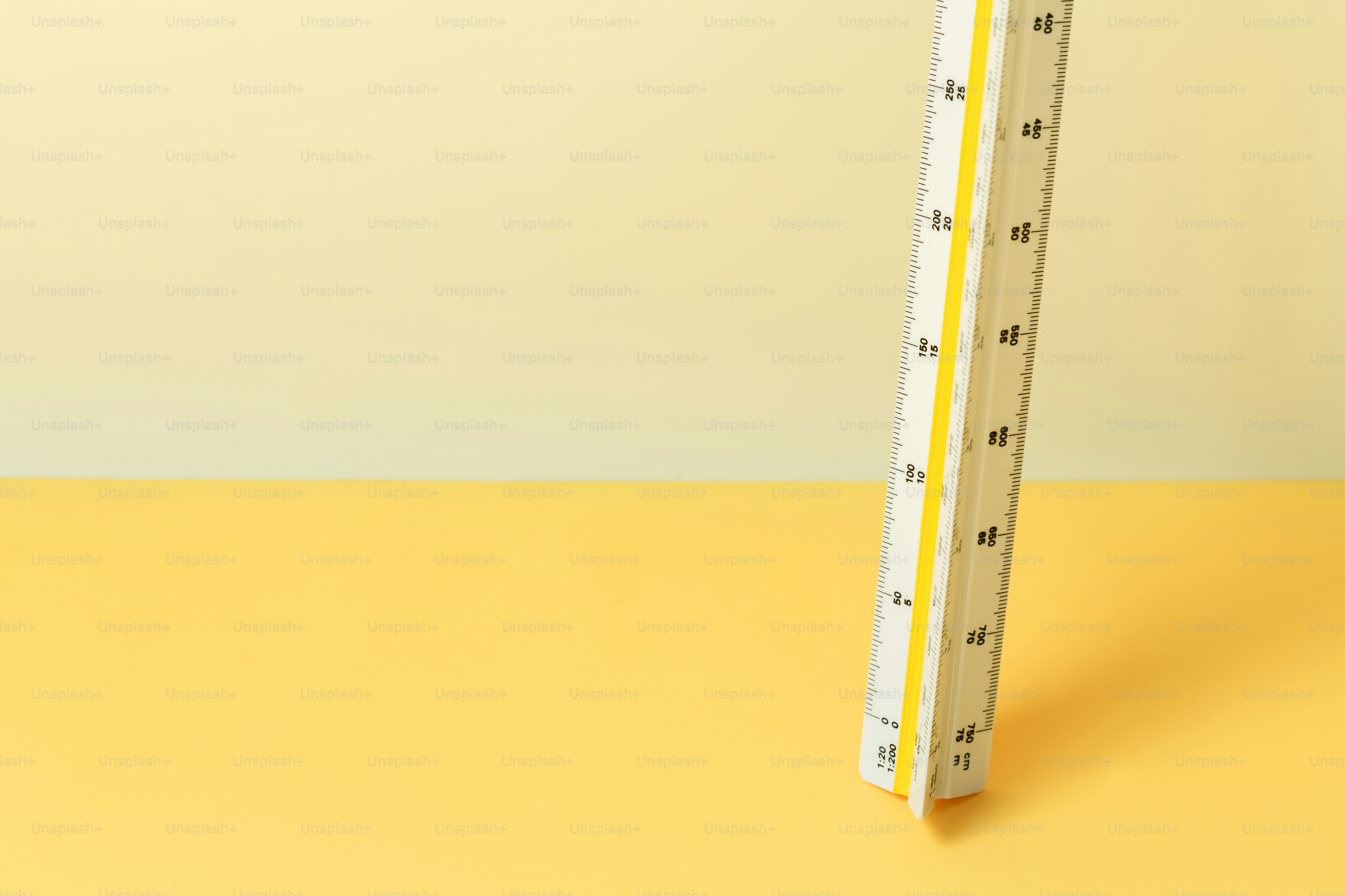 Triangular ruler standing on a yellow surface