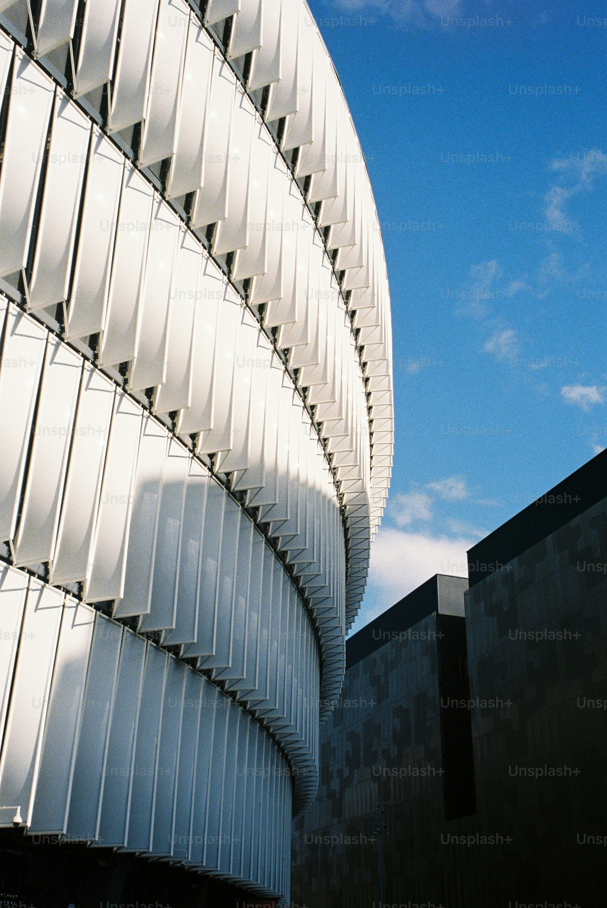Curved white building facade against blue sky
