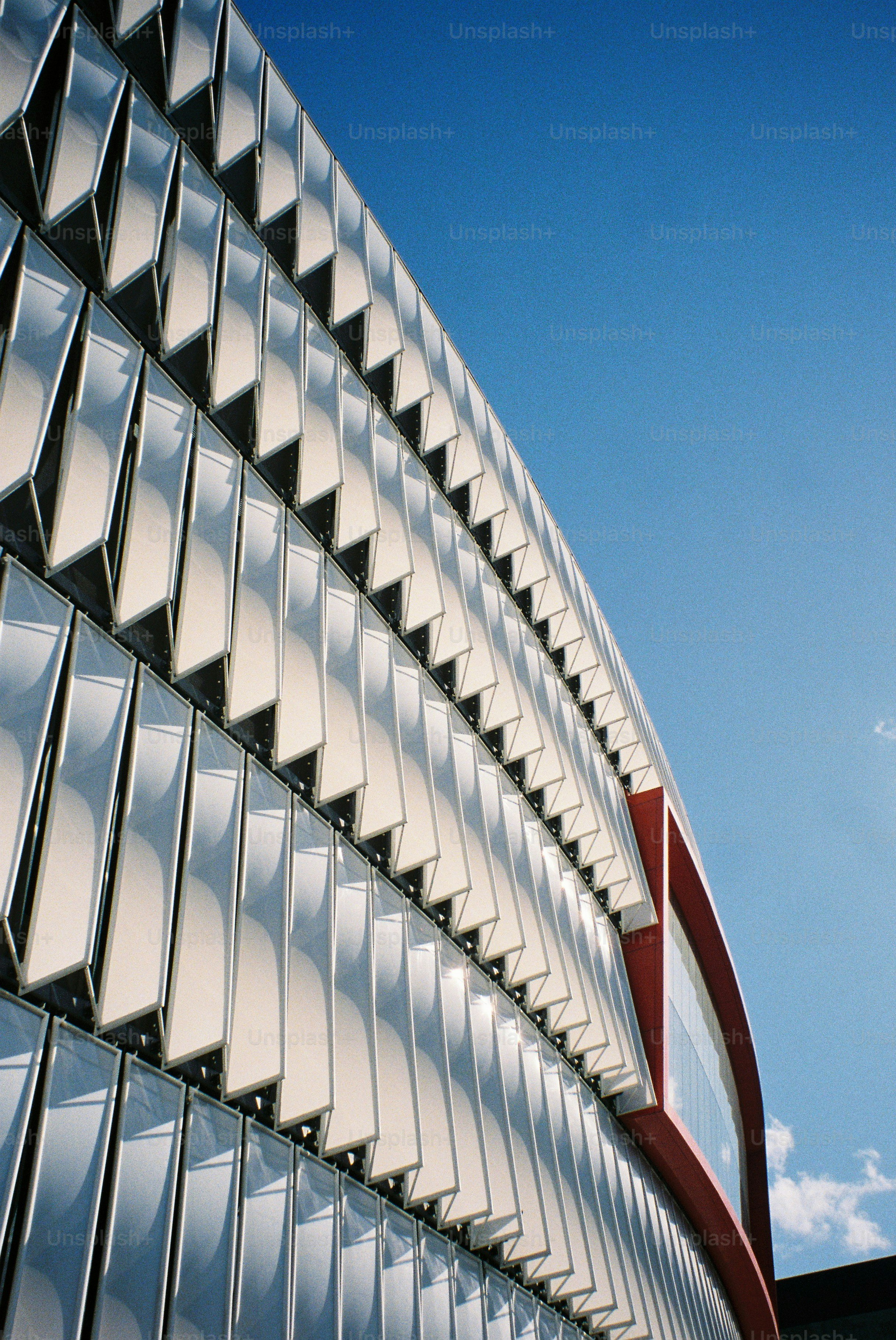 Modern building with unique glass facade and red accent