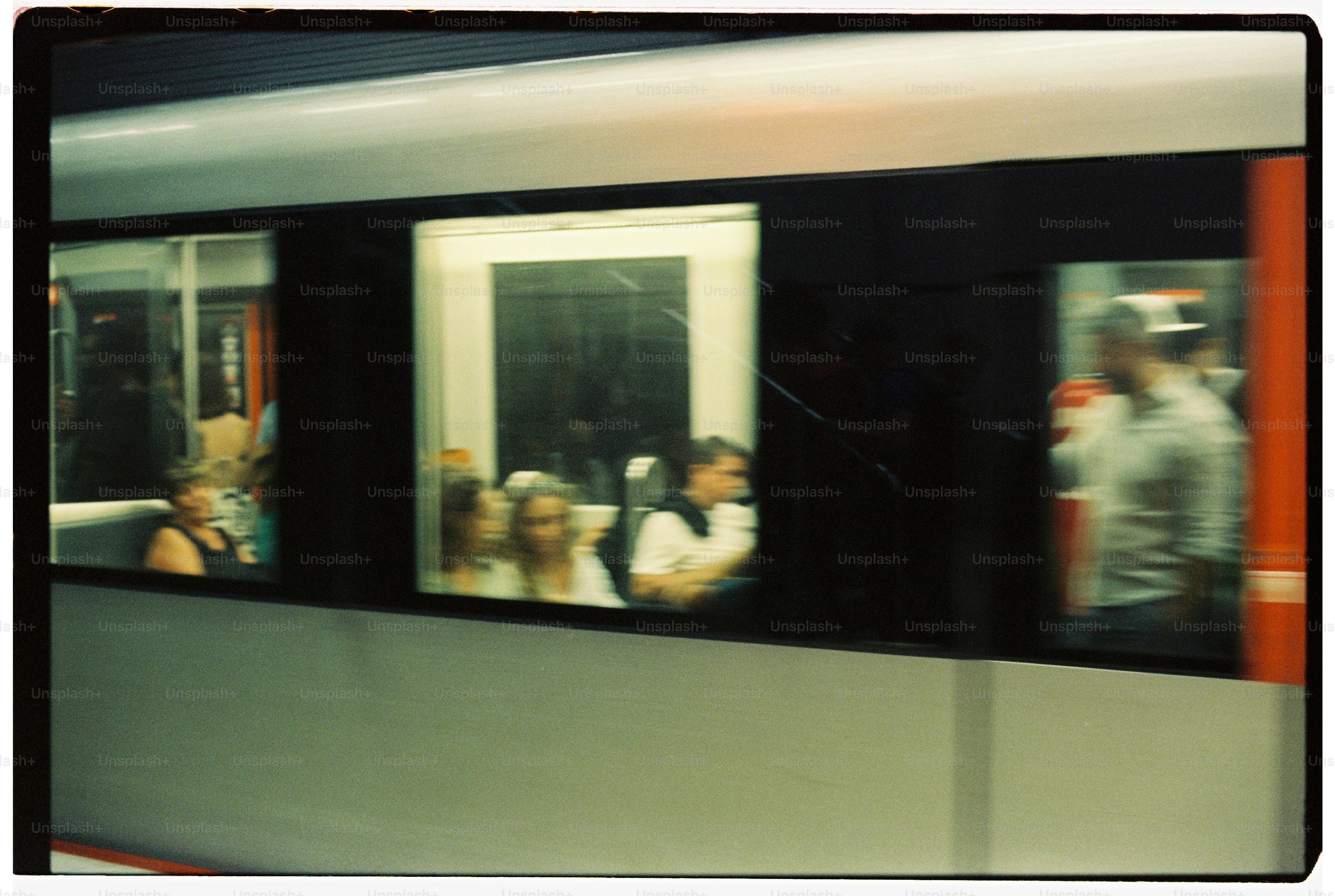 Blurred passengers seen through windows of moving train