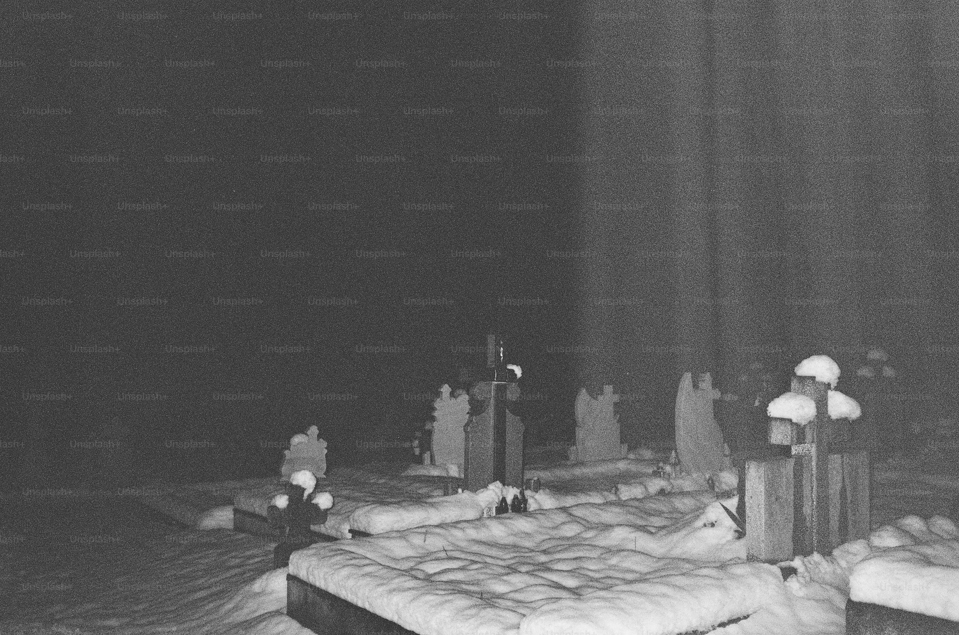Snowy graveyard at night with light beams